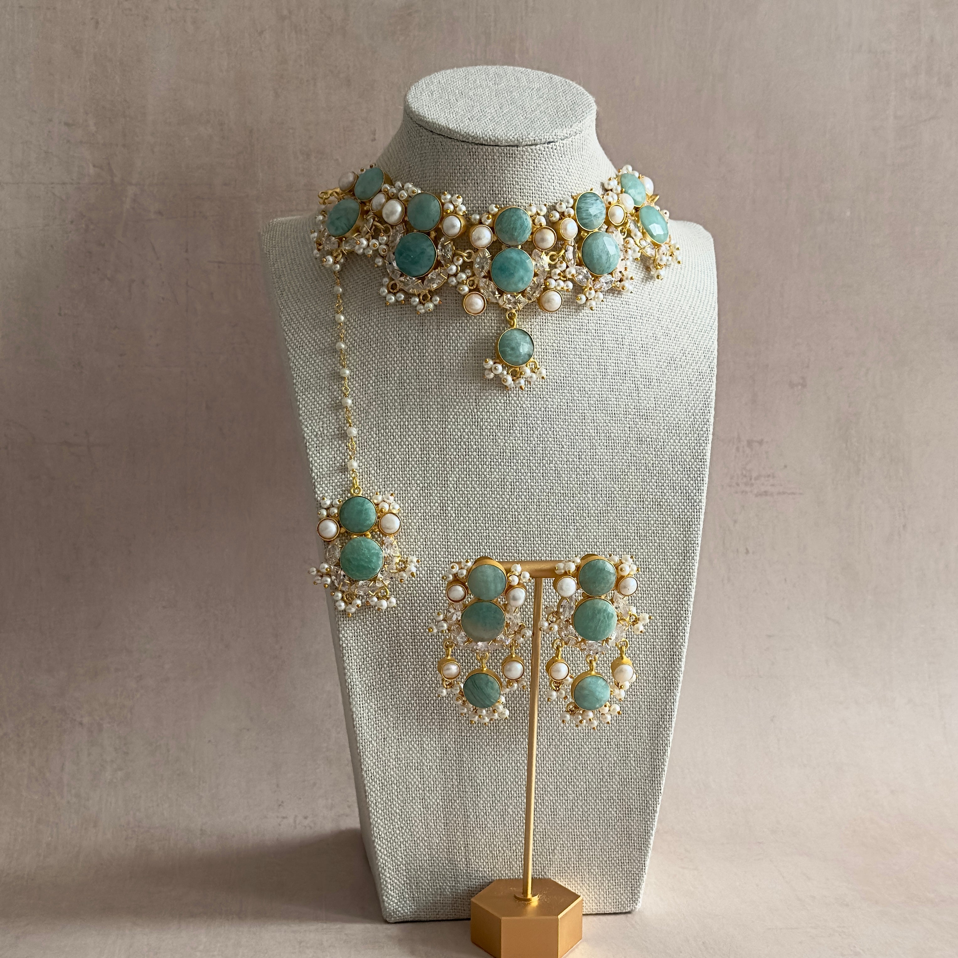 Make a statement with our Havana Jade Choker Set featuring natural amazonite stone, sparkling cubic zirconia, and unique freshwater pearls. Complete with matching earrings and tikka, this set exudes elegance and adds a touch of nature to your look. Elevate any outfit with this one-of-a-kind set!