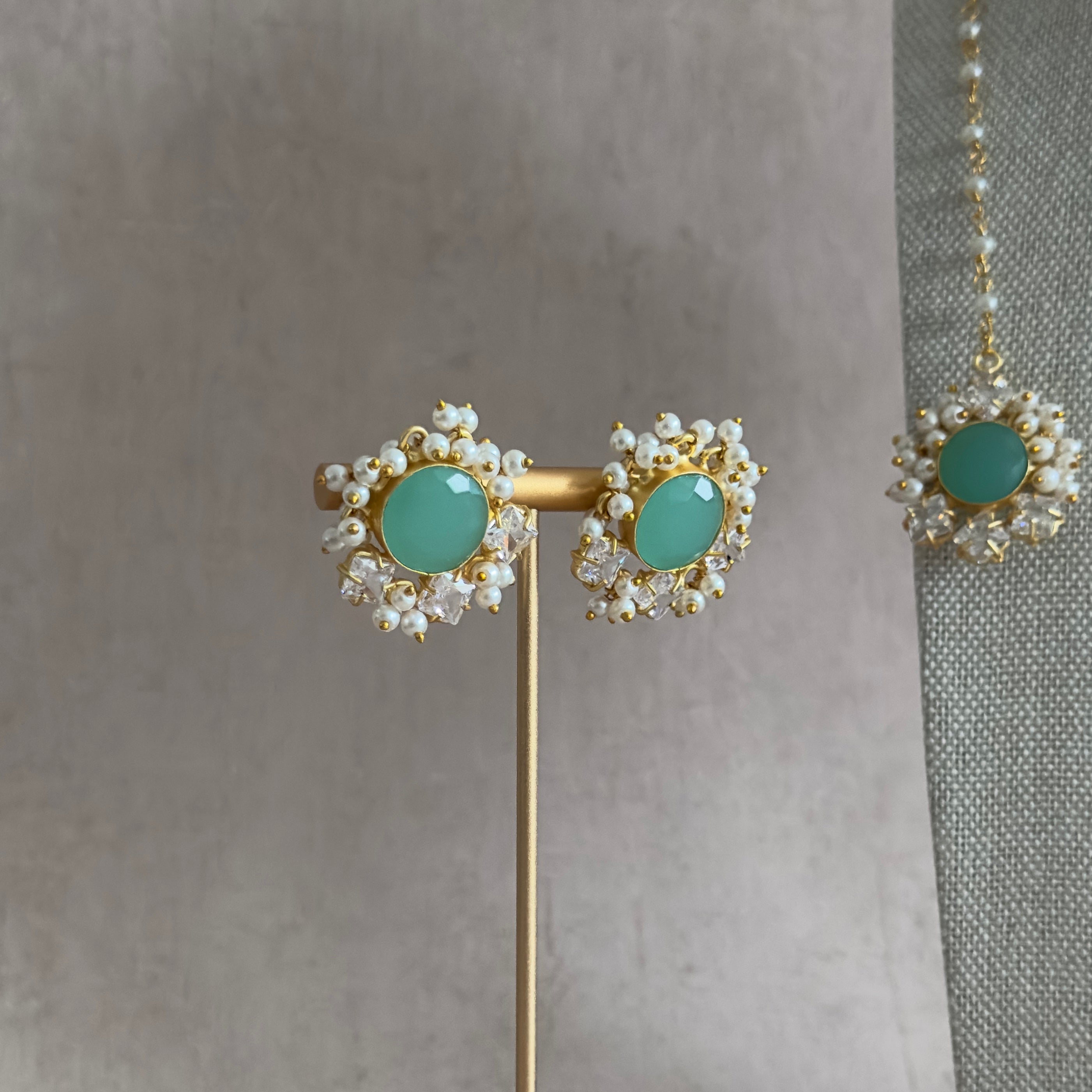 Experience the stunning hues of mint with our Grace Mint Crystal Choker Set. The glowing colors are beautifully paired with sparkling cubic zirconia for an irresistible combination. The adjustable chain tie allows for the perfect fit, and it comes complete with matching earrings and tikka. Elevate your look with this elegant set!