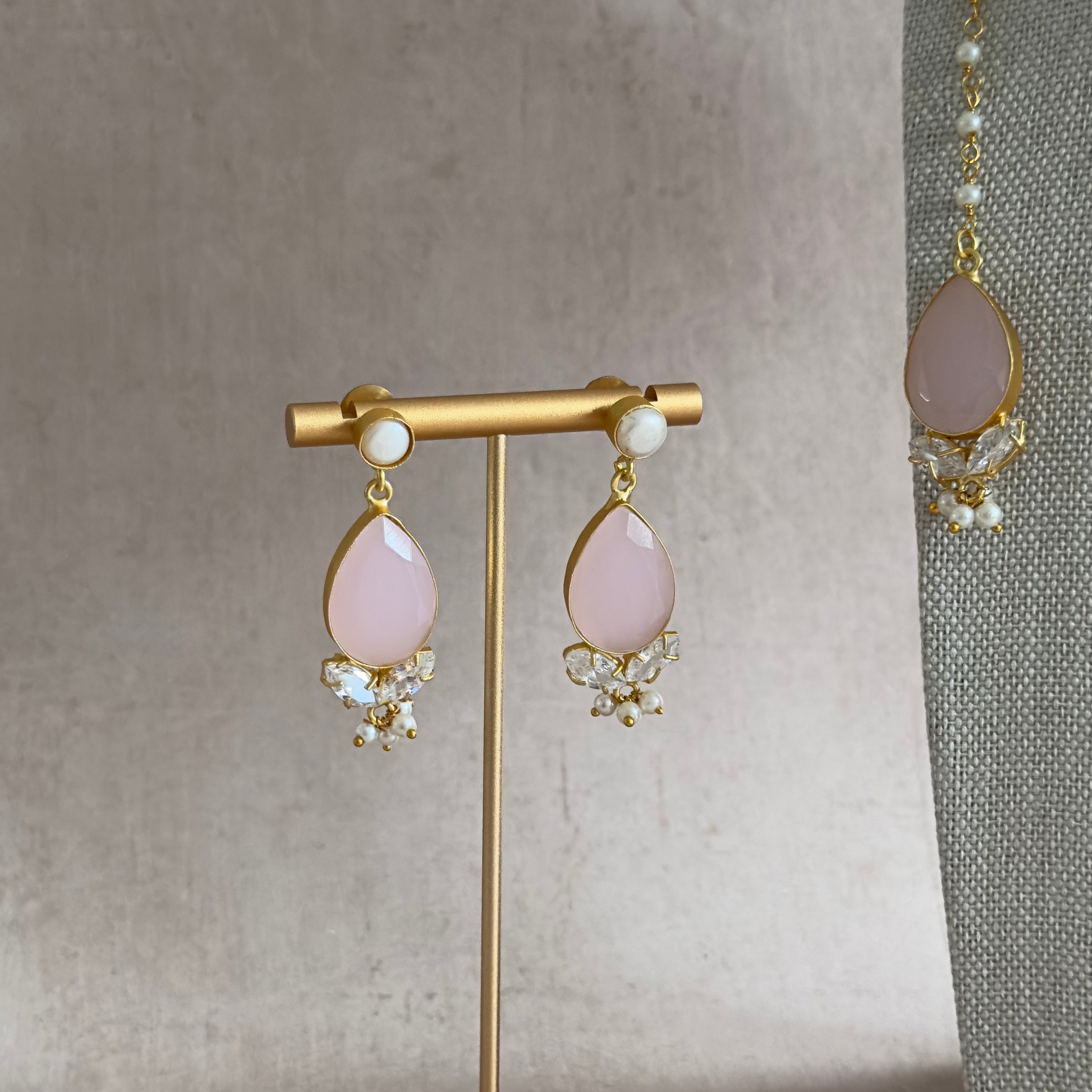 Bring a touch of elegance to any outfit with our Ari Pink Choker Set! Featuring beautiful freshwater pearls and exquisite cubic zirconia, this set is sure to elevate your look. The adjustable chain ensures a perfect fit, and it comes complete with matching earrings and tikka for a glamorous stunning look.