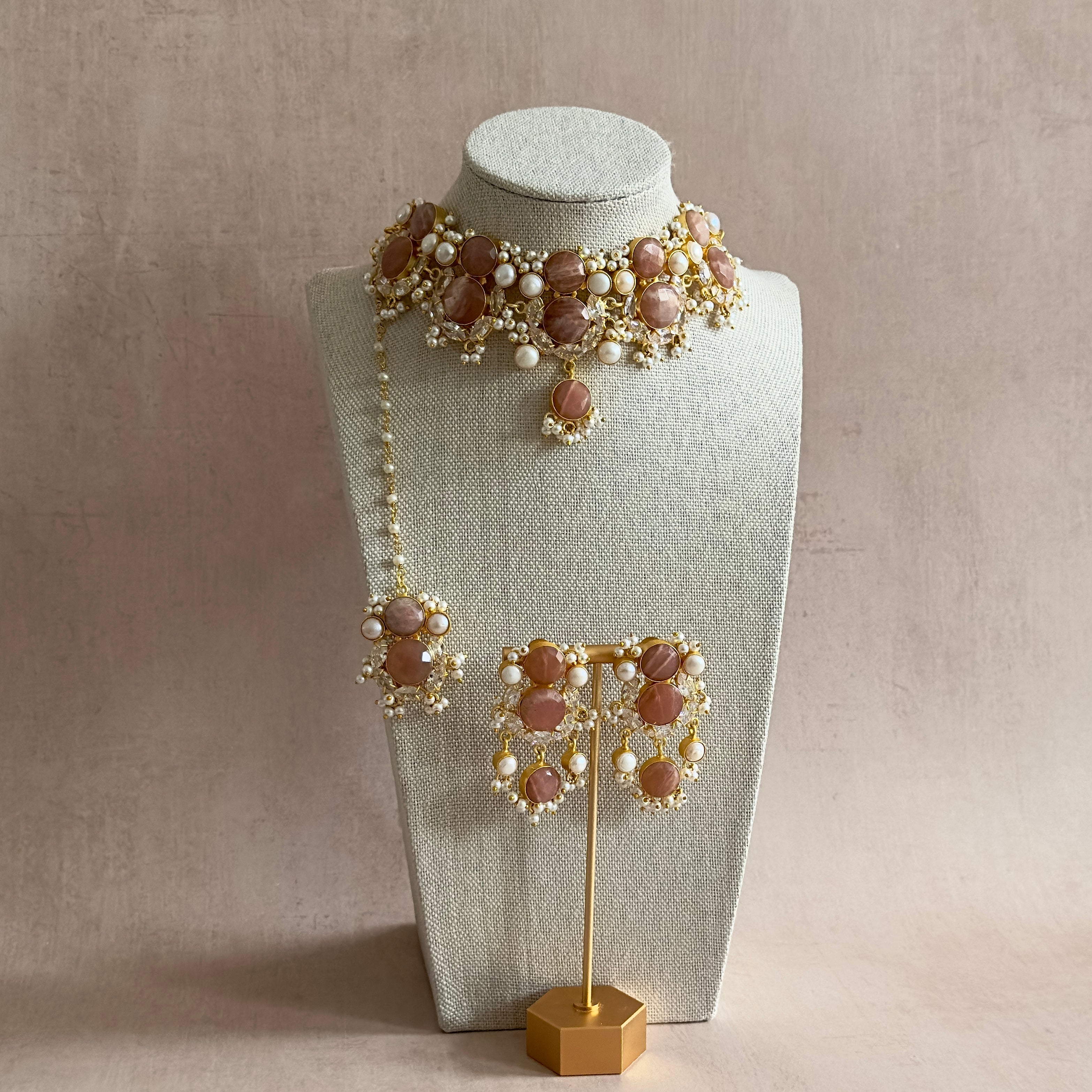 Elevate your look with our Havana Peach Choker Set. This stunning statement set features beautiful peachy brown hues adorned with lustrous freshwater pearls and sparkling cubic zirconia. The adjustable chain ensures a perfect fit, and it comes complete with matching earrings and tikka. Indulge in luxury and sophistication with this exquisite set.