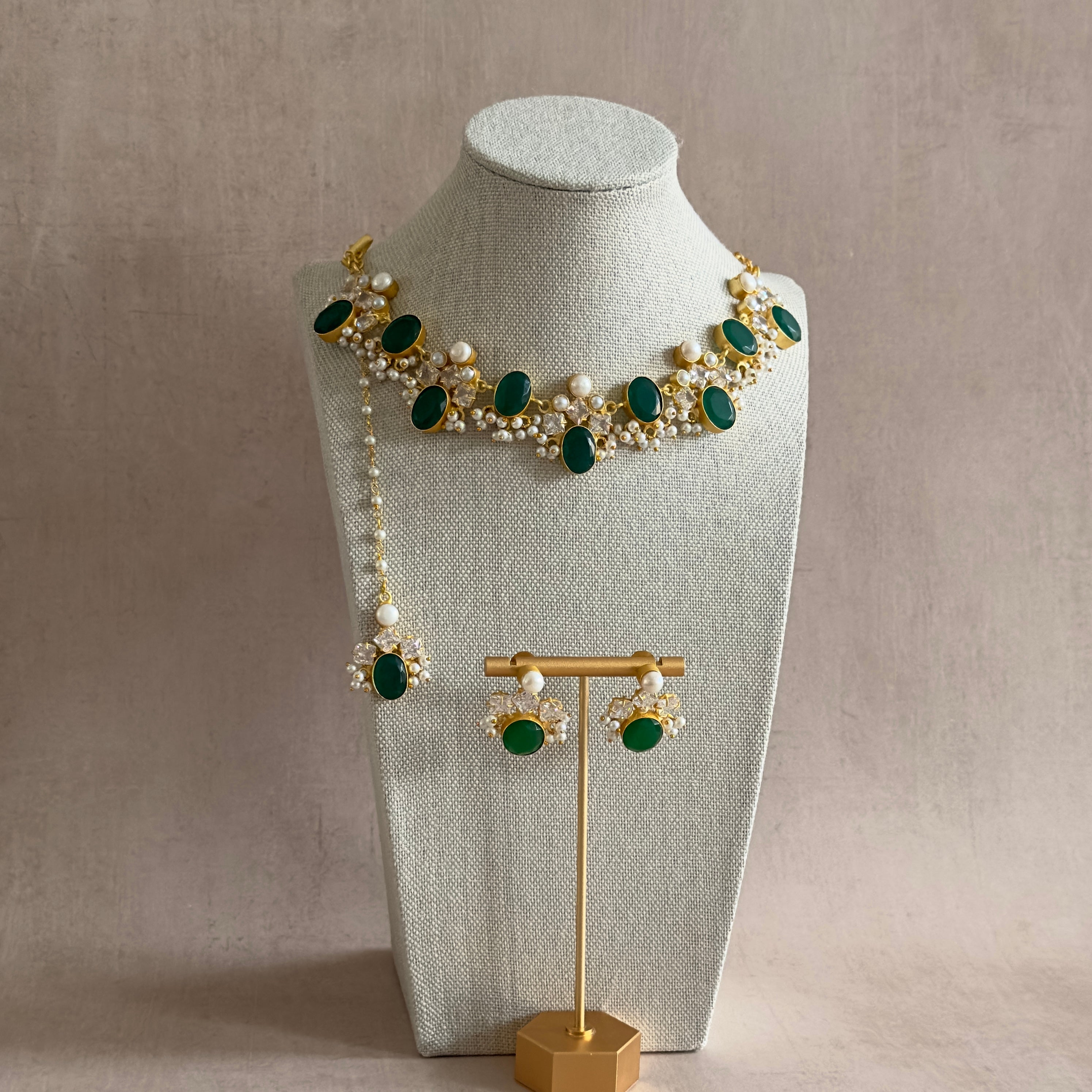 Experience the elegance of our Bisma Green Necklace Set, featuring stunning green onyx stones and freshwater pearls. The adjustable chain adds versatility, and the set comes complete with matching earrings and tikka. Elevate your look with this exclusive, sophisticated accessory.