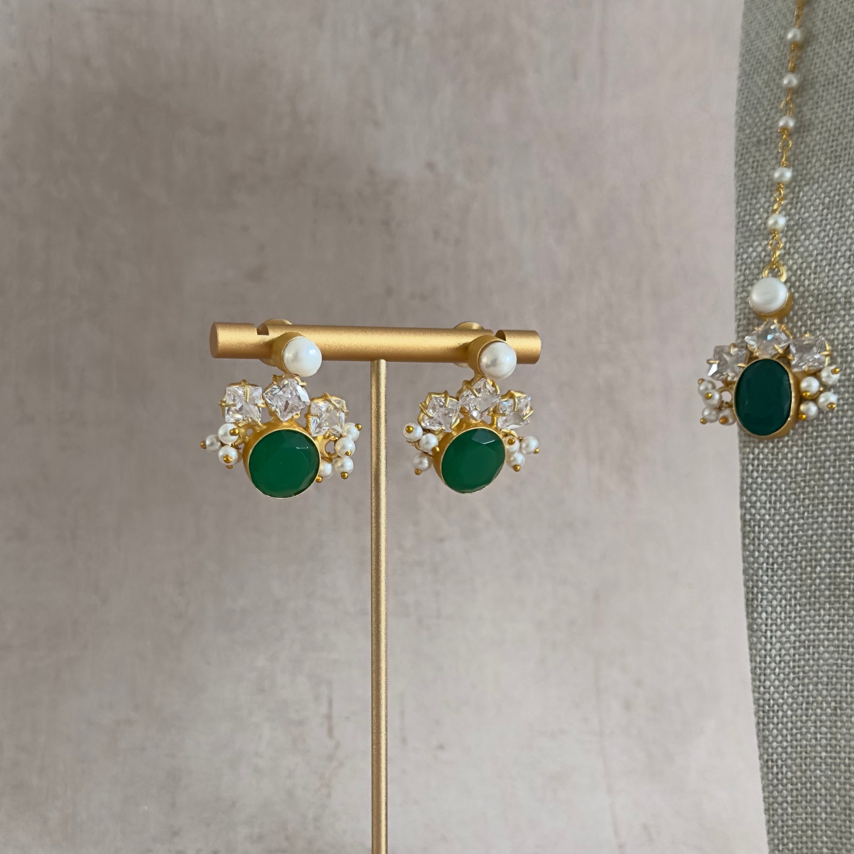 Experience the elegance of our Bisma Green Necklace Set, featuring stunning green onyx stones and freshwater pearls. The adjustable chain adds versatility, and the set comes complete with matching earrings and tikka. Elevate your look with this exclusive, sophisticated accessory.