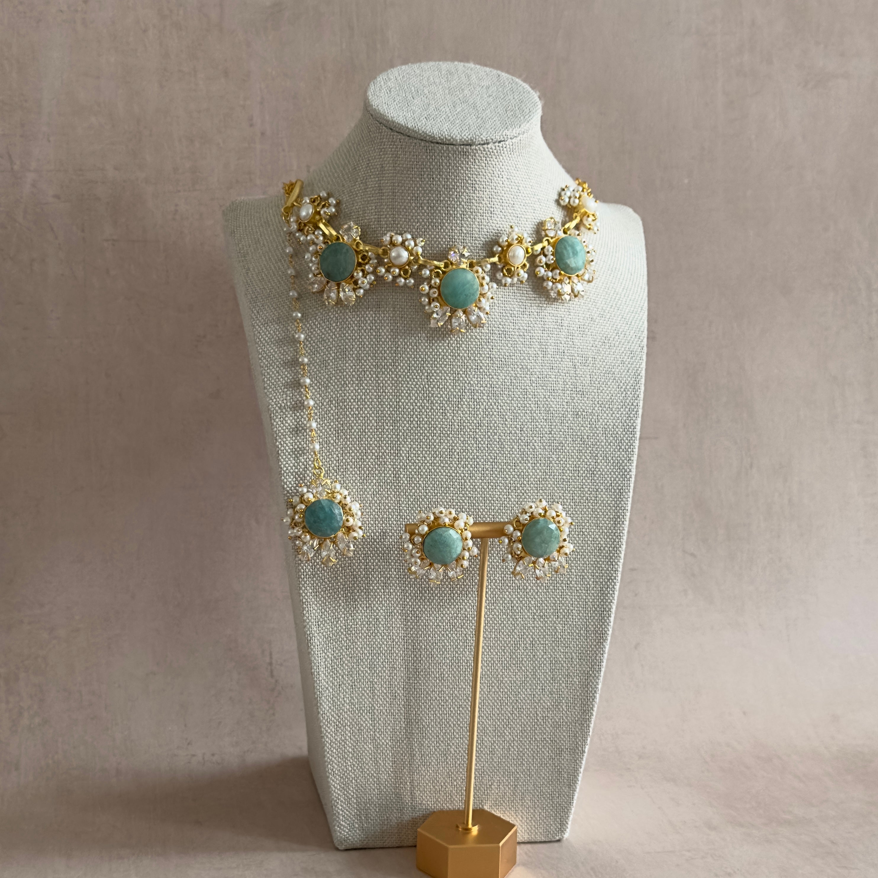 Introducing the Aroz Jade Necklace Set, a stunning accessory that combines the natural beauty of amazonite stones with the rich, luxurious hues of jade. The adjustable chain allows for the perfect fit, while the complementary earrings and tikka complete the look. Elevate your style with this exclusive and sophisticated necklace set.
