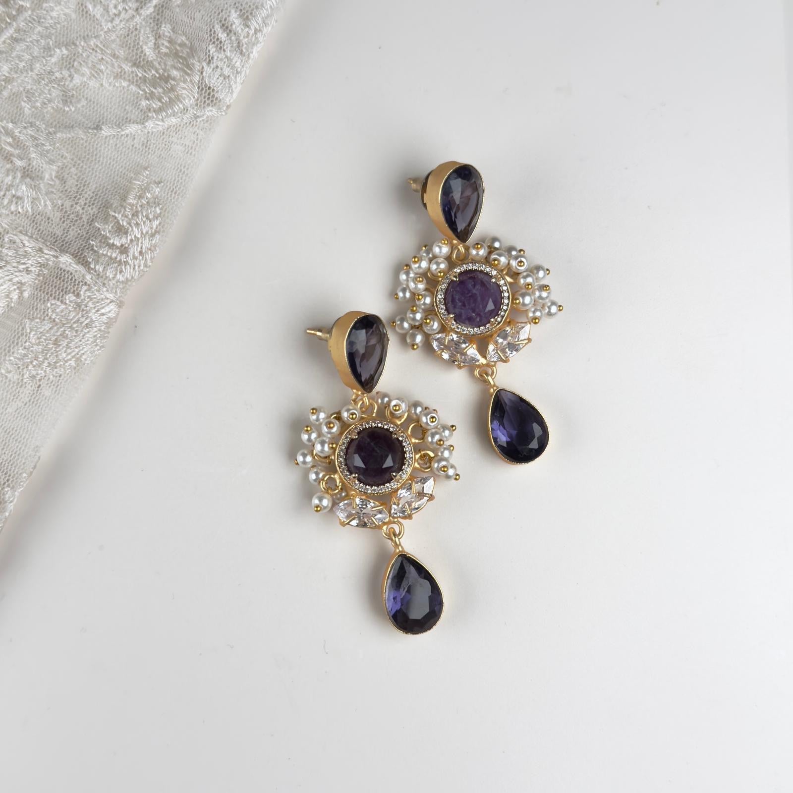 "Get ready to sparkle with these hand-cut gemstone Purple Drop Earrings! The cz crystals add a touch of shine to any outfit, making these earrings the perfect addition to your jewelry collection. Show off your unique style with these playful, yet elegant, earrings.&nbsp;
