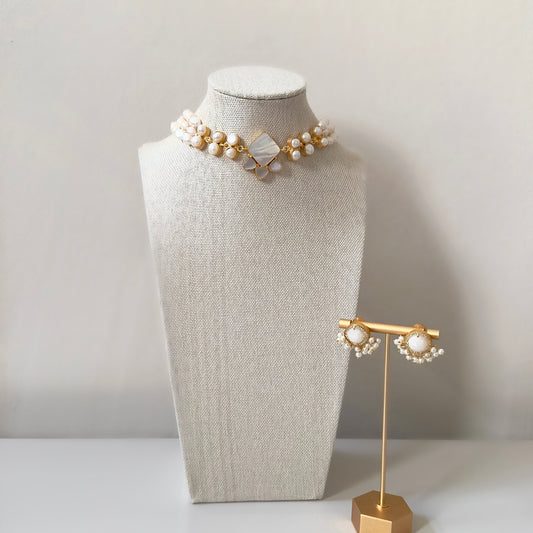 This Pearl Choker Set features a stunning mother of pearl center and elegant earrings. Add a touch of simple elegance to any outfit with this elegant choker set.<br>Adjustable chain tie.<br>Earring drop 2cm