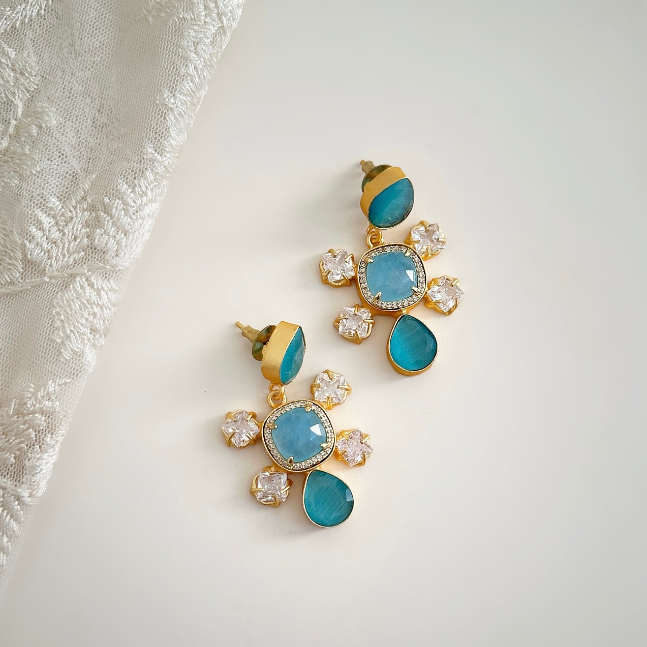 The Rosie Blue Drop Earrings are a luxurious addition to any jewelry collection. Adorned with luminous blue gemstones and sparkling cz crystals, these earrings exude elegance and sophistication. Elevate your style with these exquisite, exclusive pieces.