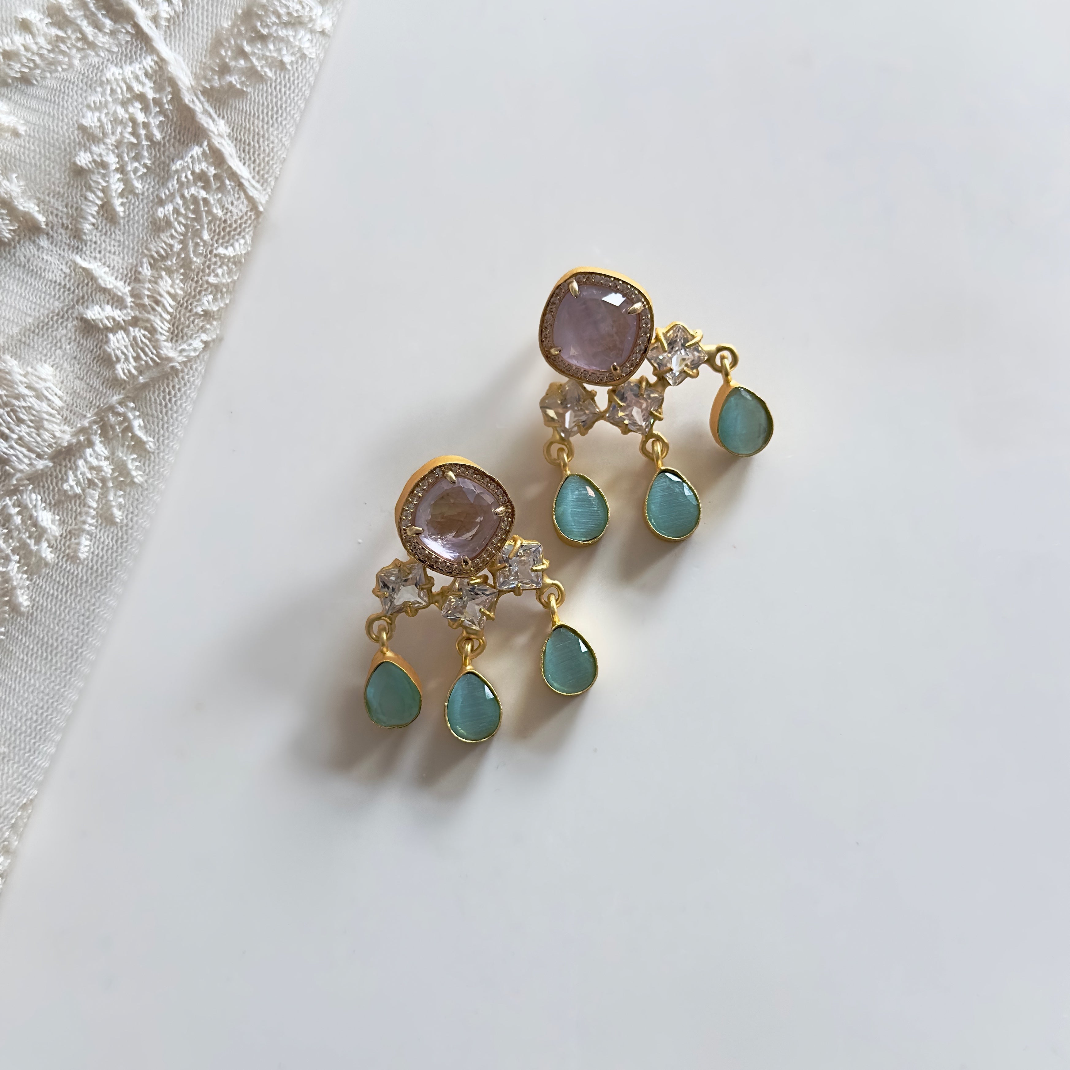 Indulge in the refreshing elegance of the Lorená Mint Drop Earrings. Adorned with hues of mint and lilac, these earrings exude sophistication and luxury. Embellished with sparkling CZ crystals, they add a touch of glamour to any outfit.&nbsp;