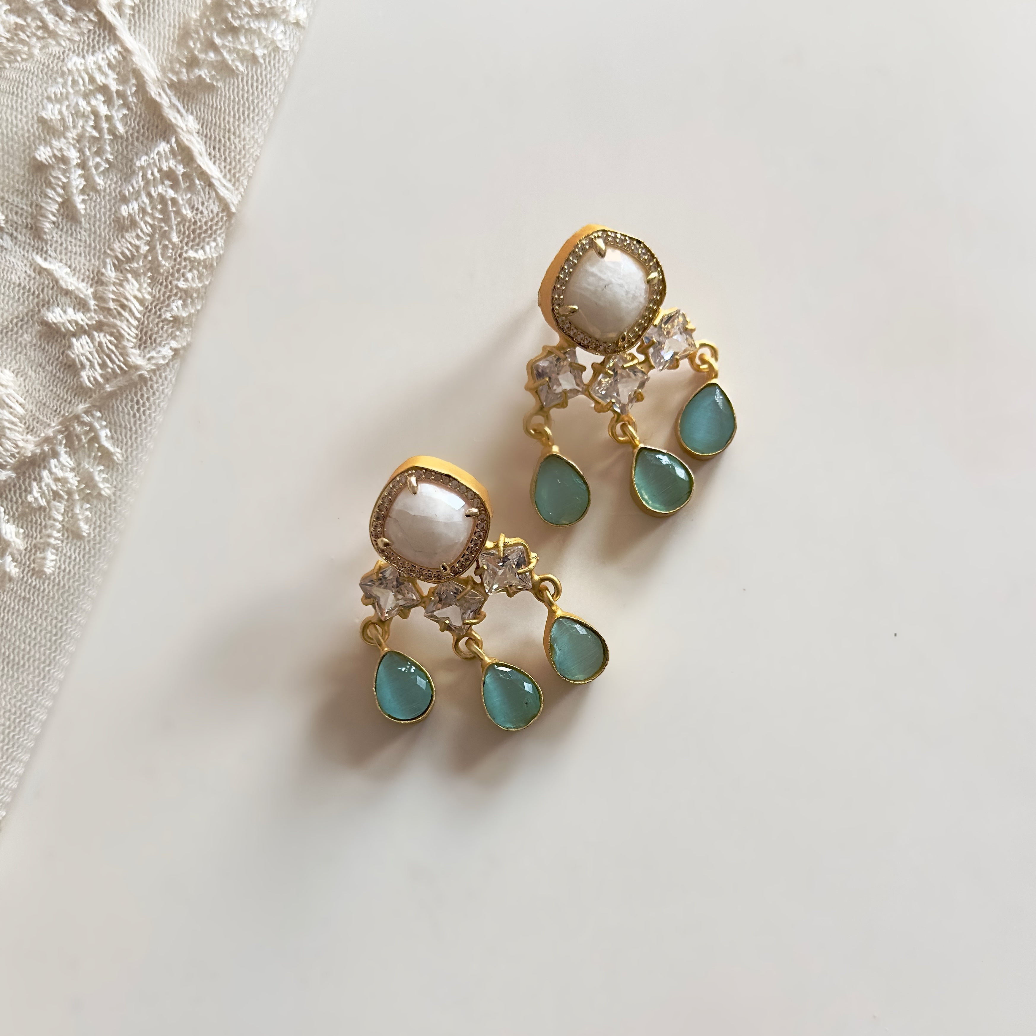 Elevate your look with the Lorená Mint Drop Earrings. The white and mint hues add a refreshing touch, while the sparkling cz crystals add a touch of elegance. Perfect for any occasion, these earrings are sure to make a statement and turn heads.