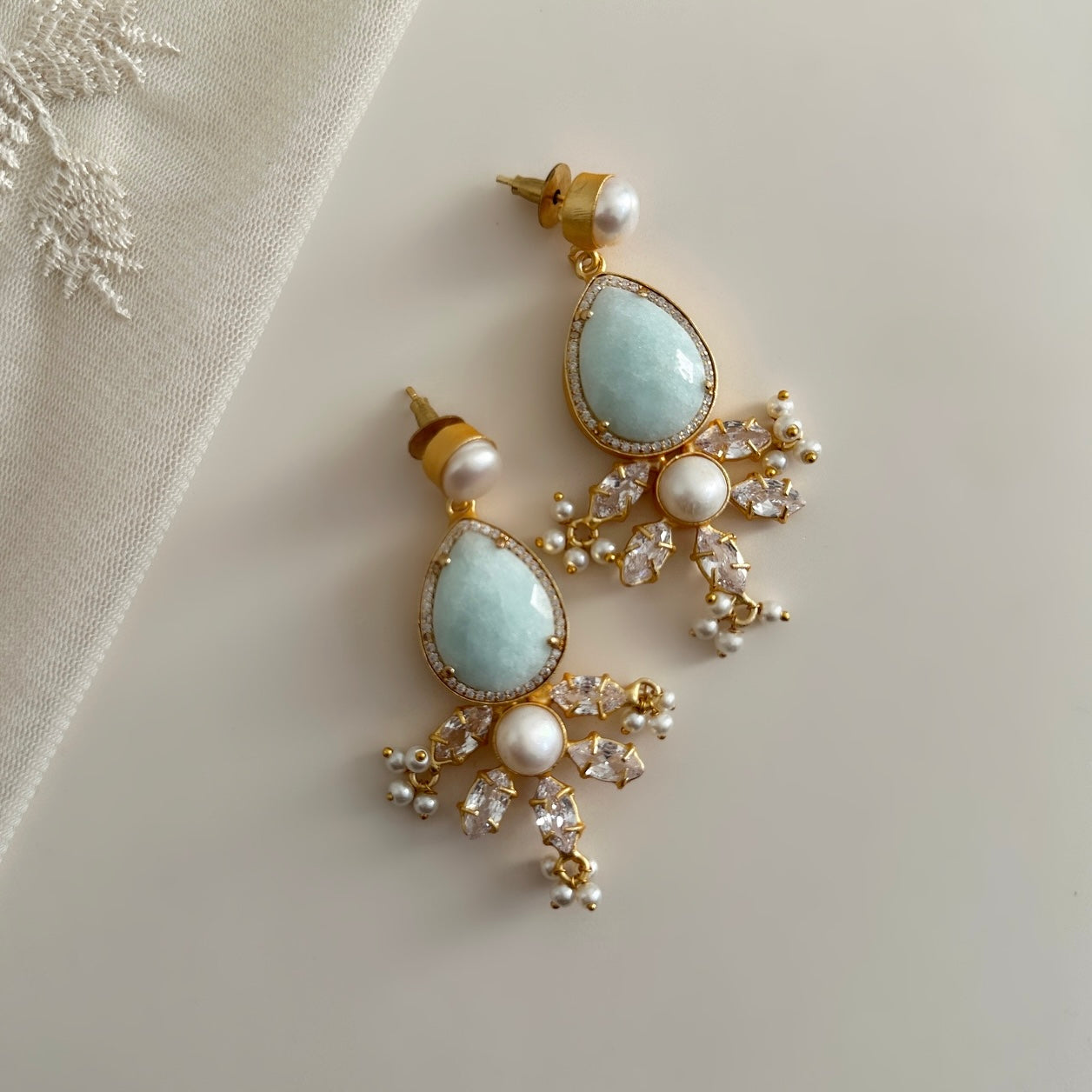Enhance your look with the elegant hues of jade and pearl in these Simone Crystal Drop Earrings. Featuring luscious CZ crystals, these earrings will add a touch of sophistication and glamour to any outfit. Elevate your style and make a statement with these stunning earrings.