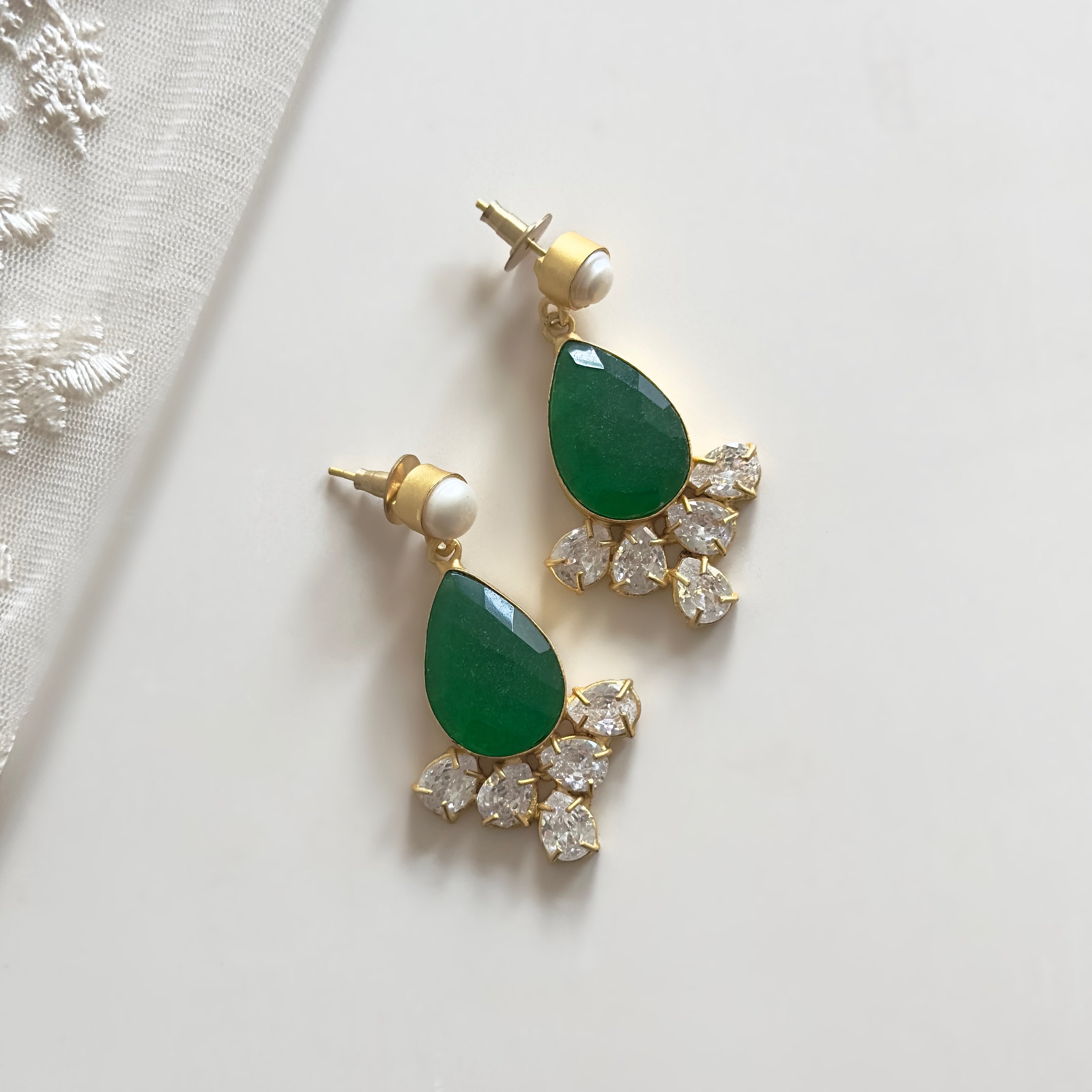 Elevate your outfit with our Holly Maroon Crystal Earrings. Featuring stunning green onyx with&nbsp; CZ crystals and a delicate pearl drop, these earrings add a touch of sophistication to any look.&nbsp;