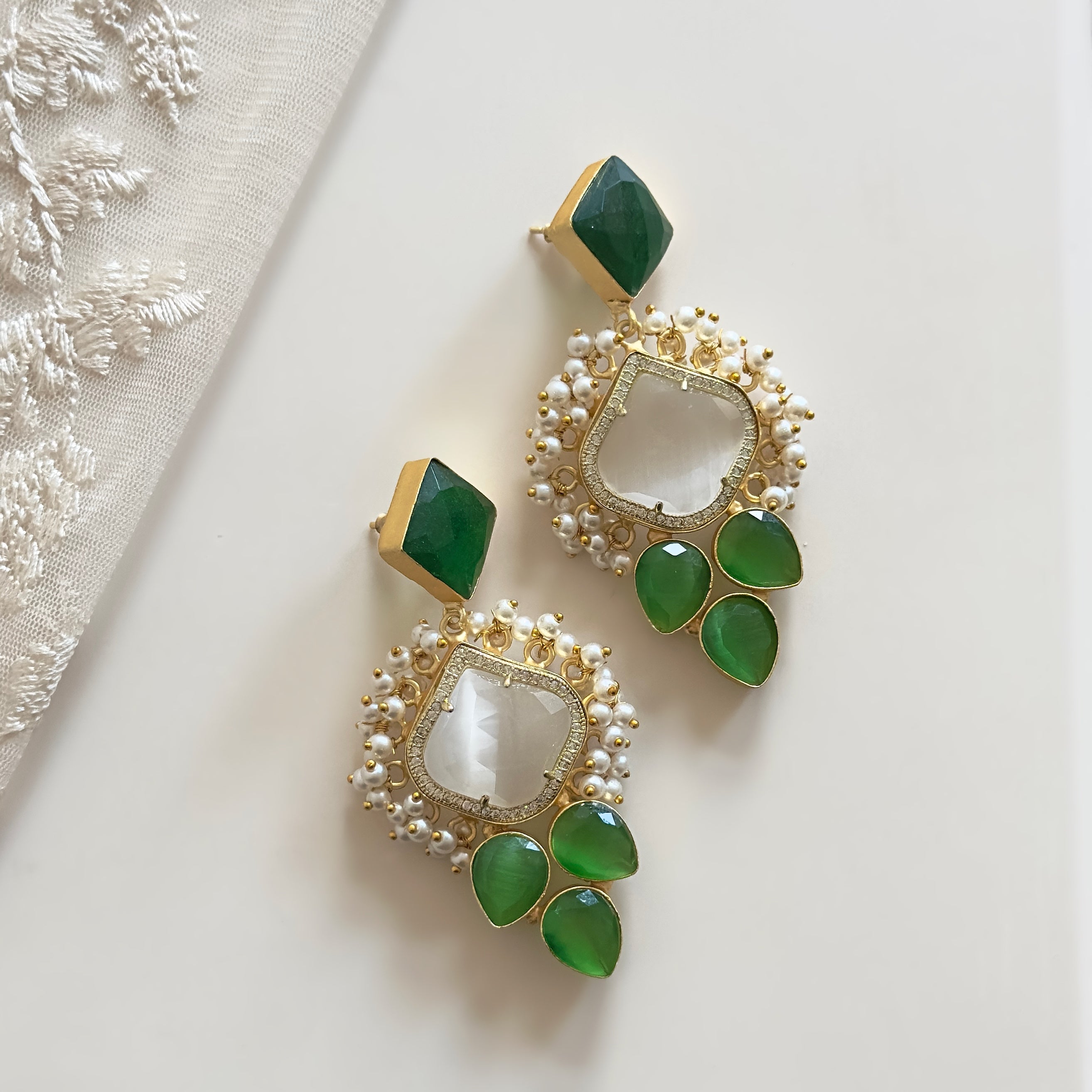 Elevate your style with our Hijra Green Earrings. Crafted with stunning green and grey gemstones, these earrings make a statement that will leave a lasting impression. Perfect for any occasion, these earrings are a must-have for those looking to make a sophisticated yet bold fashion statement.