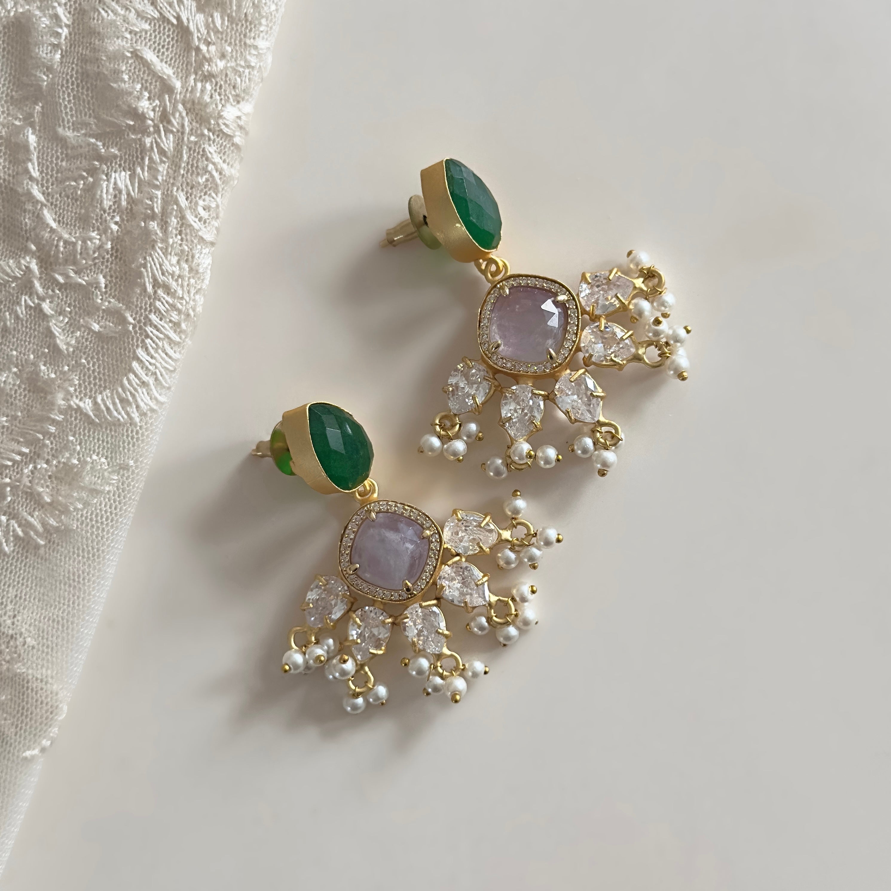 These Harper Green Drop Earrings feature a stunning mix of green and lilac hues, creating a striking and versatile accessory. Adorned with cz crystals, these earrings add an elegant sparkle to any outfit. Elevate your style with these must-have earrings!