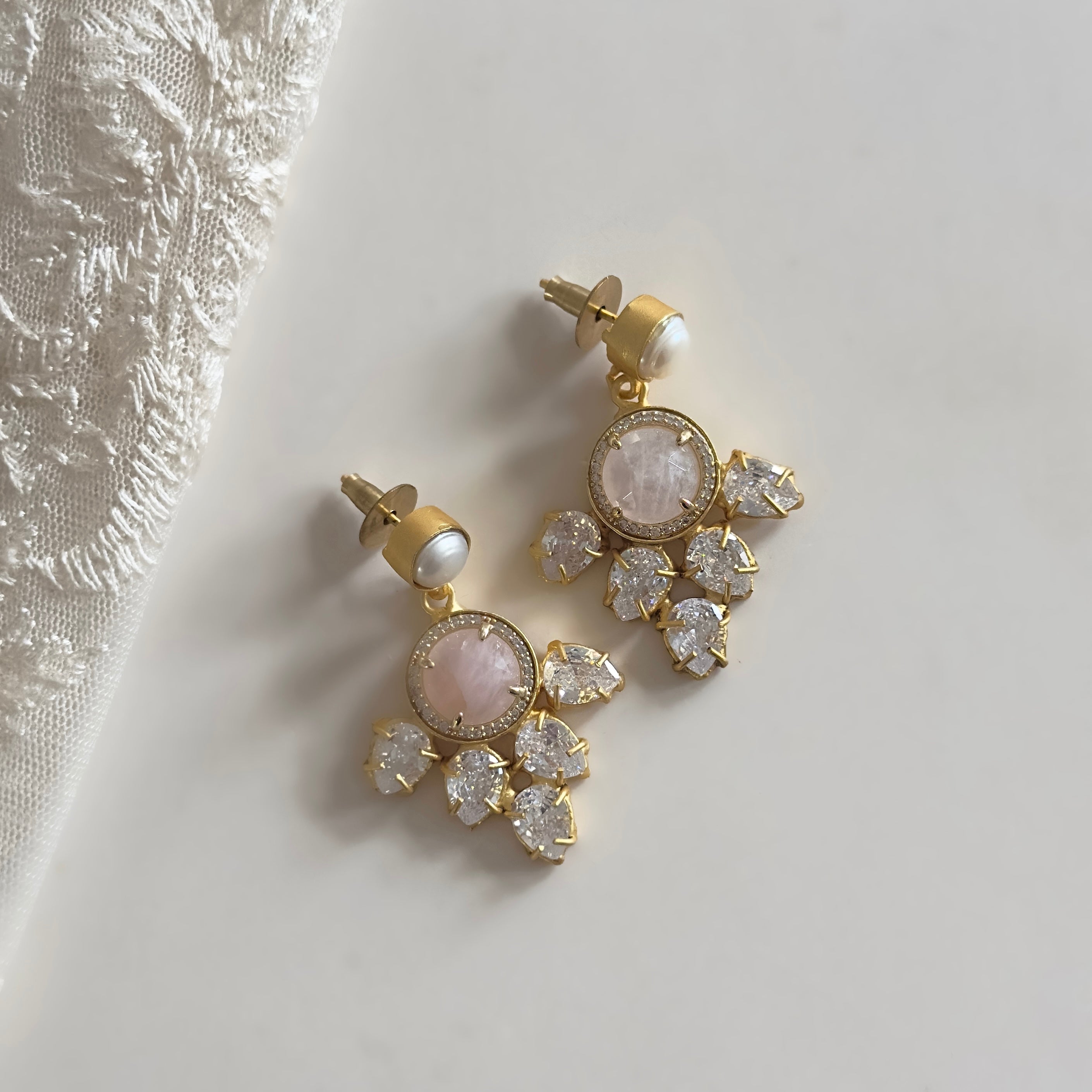 These Pink Crystal Drop Earrings will add a touch of elegance to any outfit with their blush pink stone and sparkling CZ crystals. Add a pop of color and shine to your look and make a statement with these stunning earrings. Perfect for any occasion.