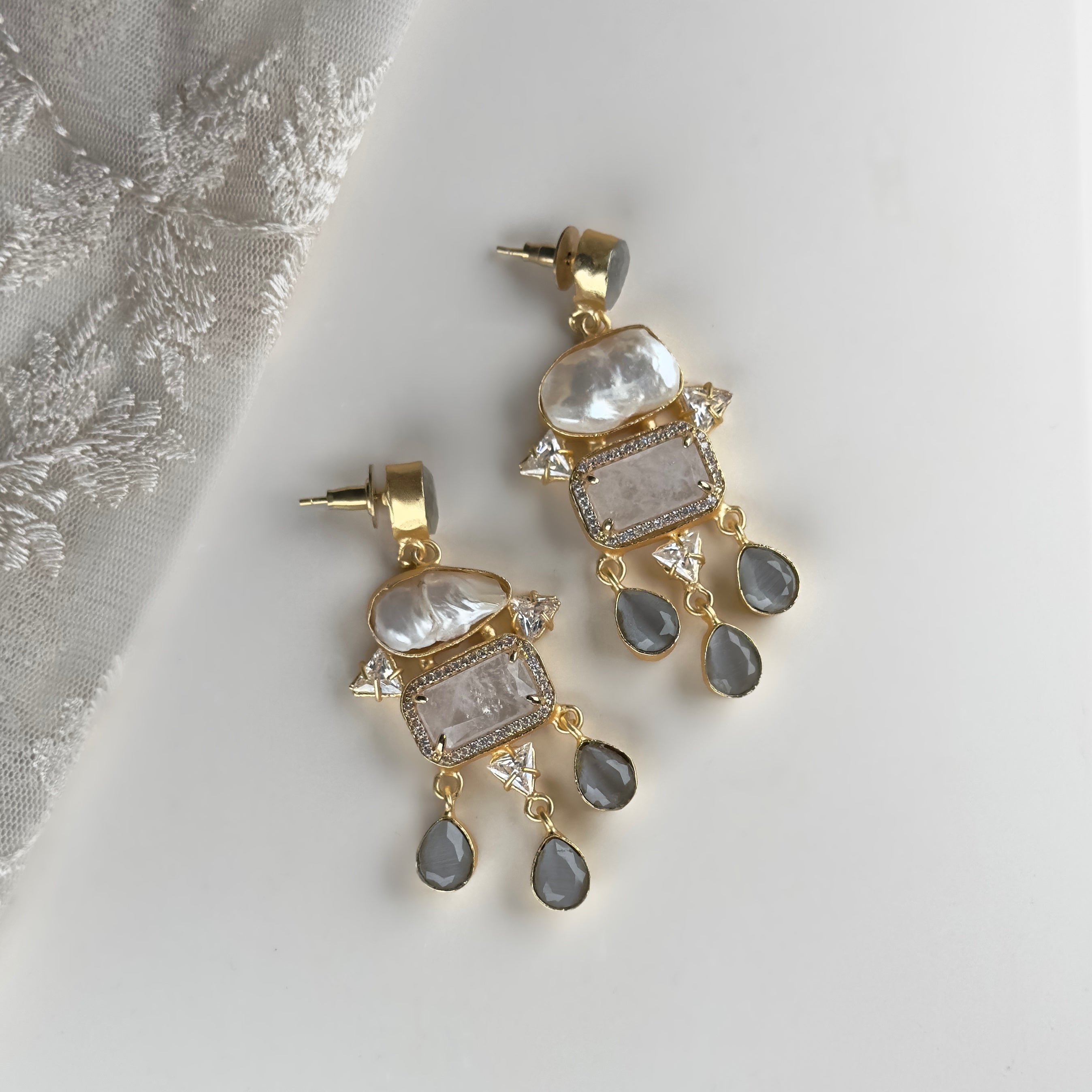 Complement your elegant style with our Safa Grey Drop Earrings. Featuring baroque pearls with beautiful hues of grey, white quartz and subtle accents of CZ crystals, these earrings add a touch of sophistication to any outfit. Elevate your look effortlessly and make a statement with these stunning earrings.