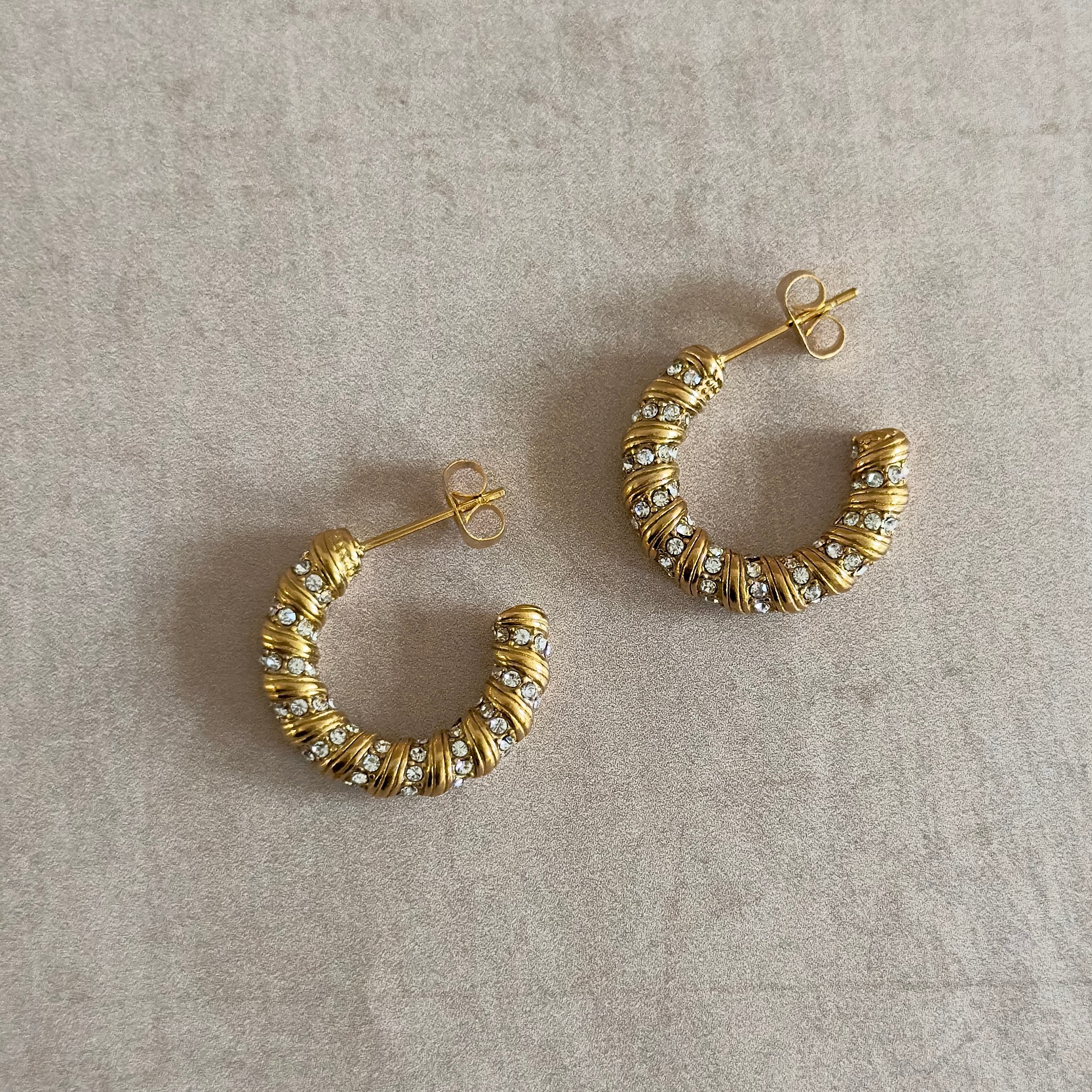 Elevate your style with the Gigi Crystal Gold Earrings. Crafted with 18k gold plating and sparkling cubic zirconia, these earrings exude luxury and sophistication. Perfect for any occasion, let them be your go-to accessory for a touch of elegance.