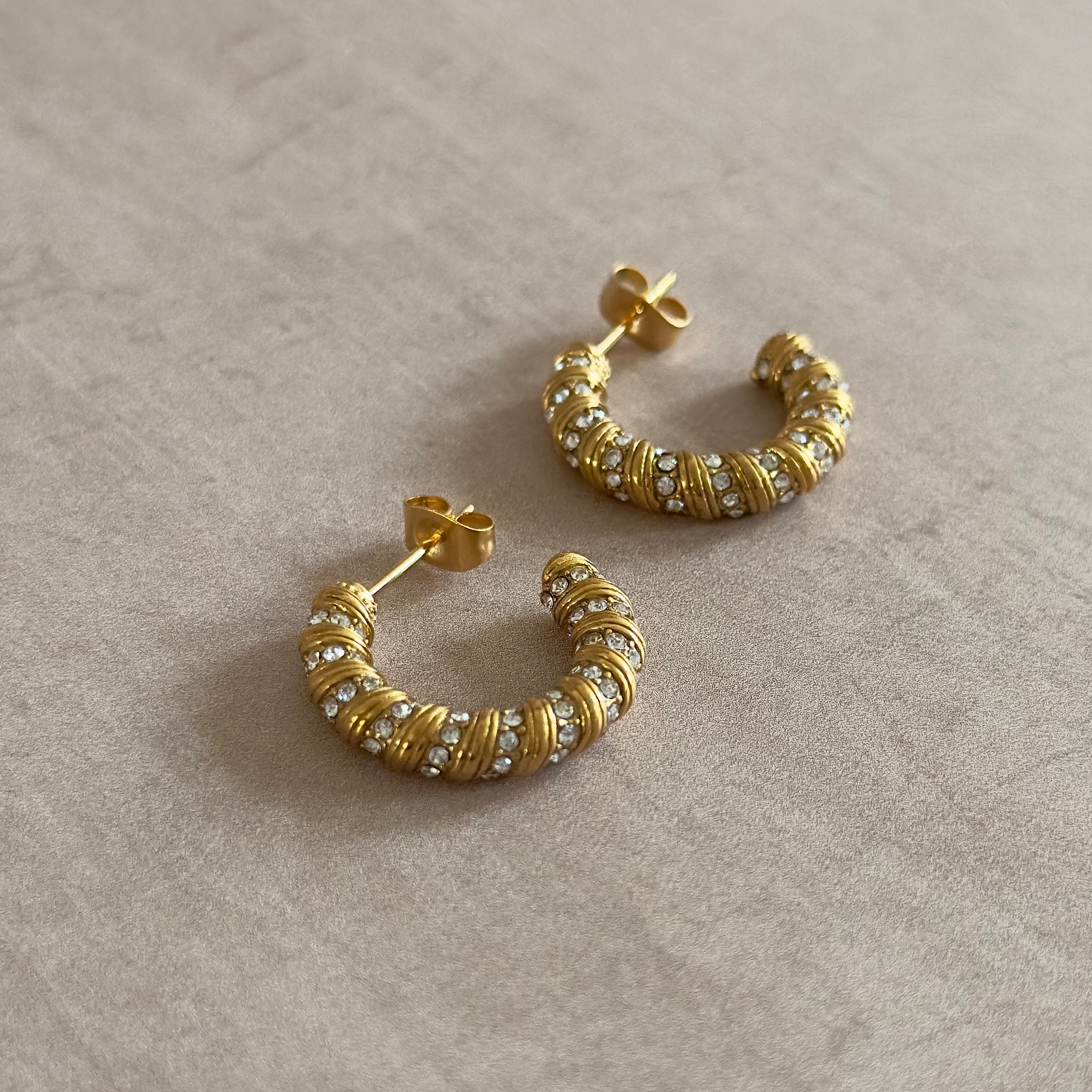 Elevate your style with the Gigi Crystal Gold Earrings. Crafted with 18k gold plating and sparkling cubic zirconia, these earrings exude luxury and sophistication. Perfect for any occasion, let them be your go-to accessory for a touch of elegance.