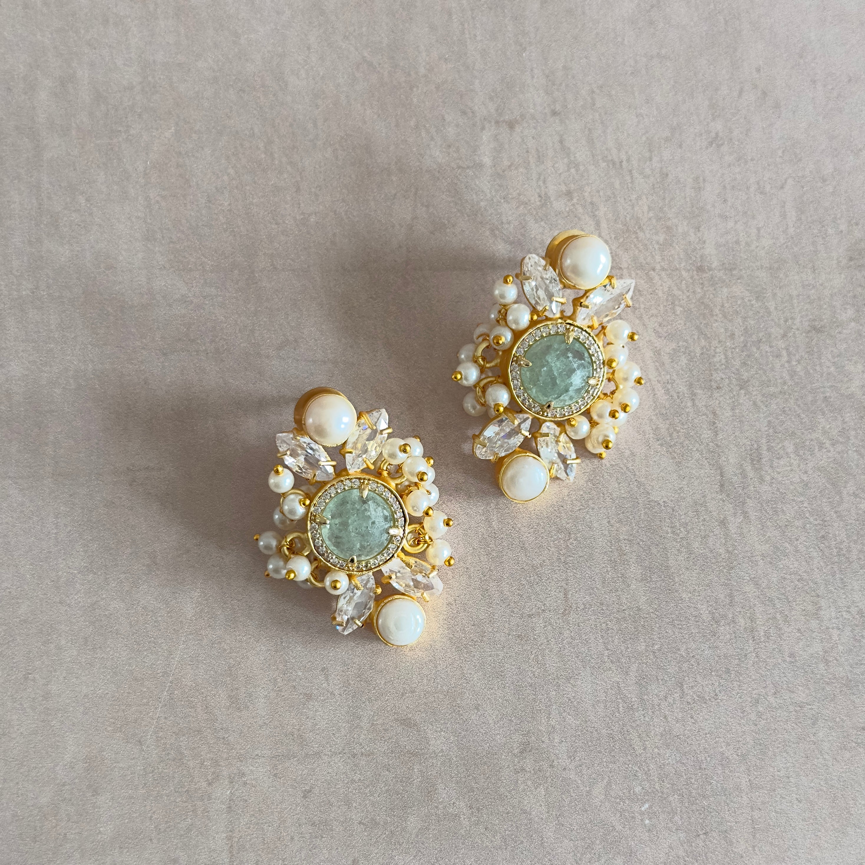 Experience the mesmerizing beauty of our Hena Crystal Pearl Earrings. Featuring aquamarine crystals and cubic zirconia, these earrings will add an elegant touch to any outfit. The pearl accents add a touch of sophistication, making them perfect for special occasions. Elevate your style with these stunning earrings.