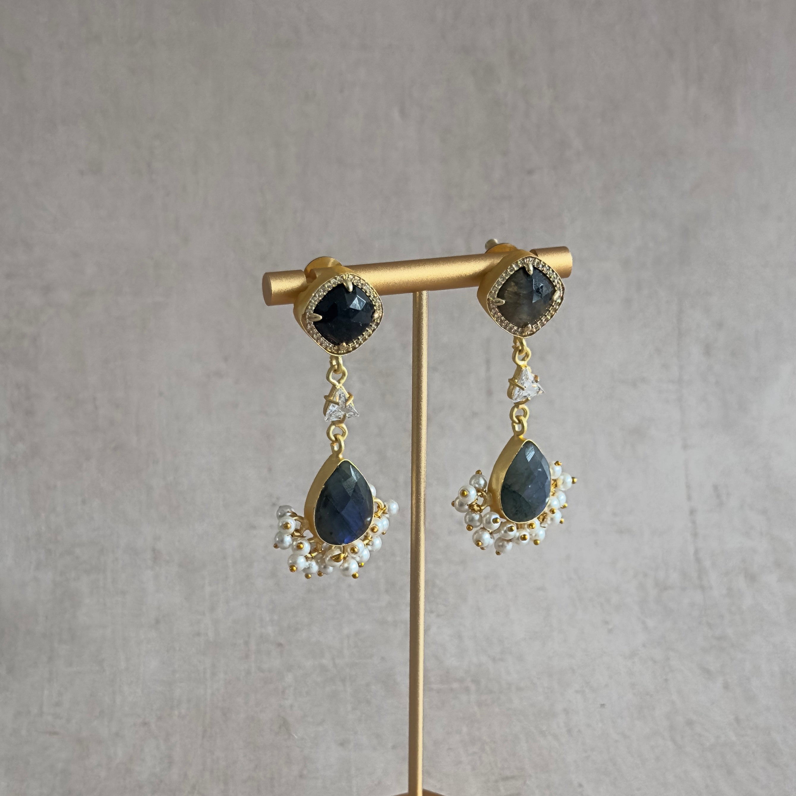 Elevate any look with these Sarah Crystal Drop Earrings, featuring lustrous labradorite stones and a dazzling cubic zirconia crystal. Add a touch of elegance and sparkle to any outfit.