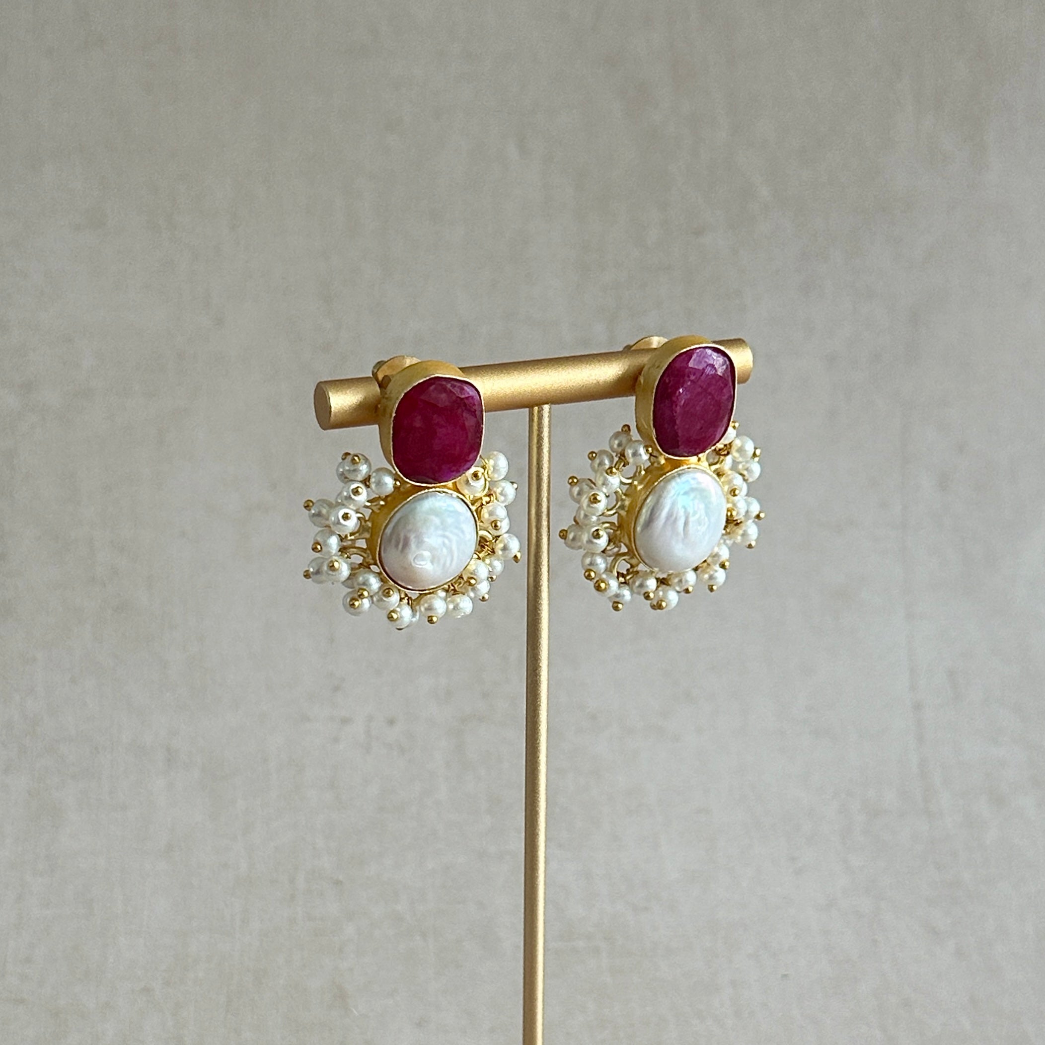 Crafted with a striking red corundum and a unique textured pearl, the Siren Pearl Stud Earrings are the perfect blend of elegance and boldness. The brilliant red hue of the corundum adds a touch of sophistication while the pearl's texture adds a unique twist to any outfit. Elevate your style with these exquisite earrings.