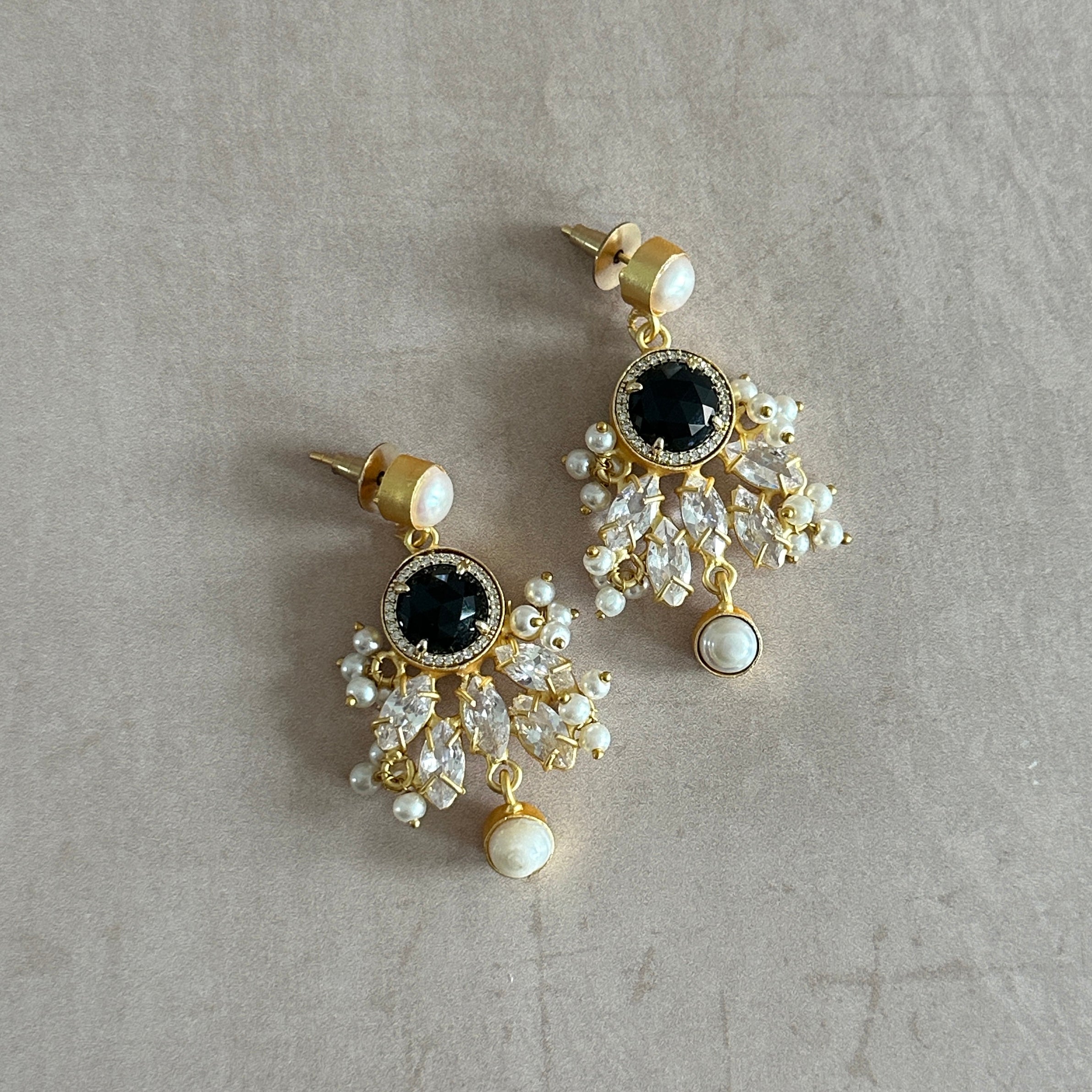 Add a touch of elegance to your look with our Black Crystal Drop Earrings. Made with stunning cubic zirconia and delicate pearl accents, these earrings are perfect for any occasion. Get the sparkle and sophistication you want in one beautiful piece.