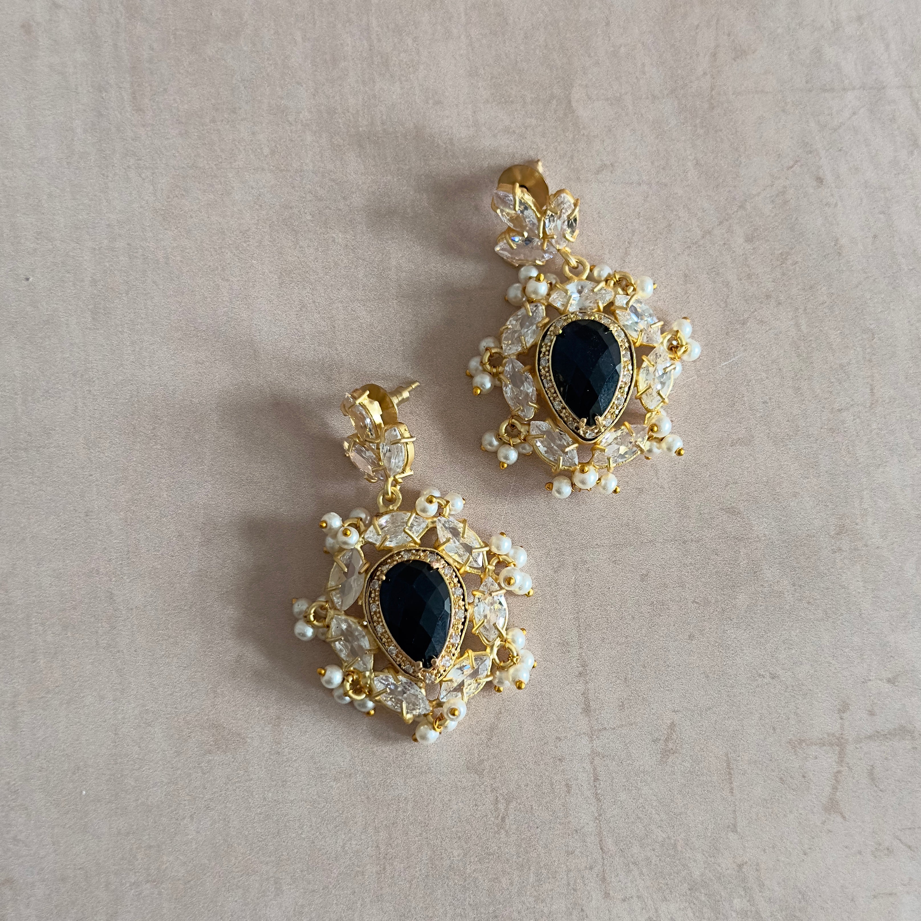 Elevate your style with our Tahira Black Crystal Drop Earrings. Crafted with stunning black onyx and sparkling cubic zirconia, these statement earrings add a touch of sophistication and glamour to any outfit. Fashion meets elegance with these must-have accessories.