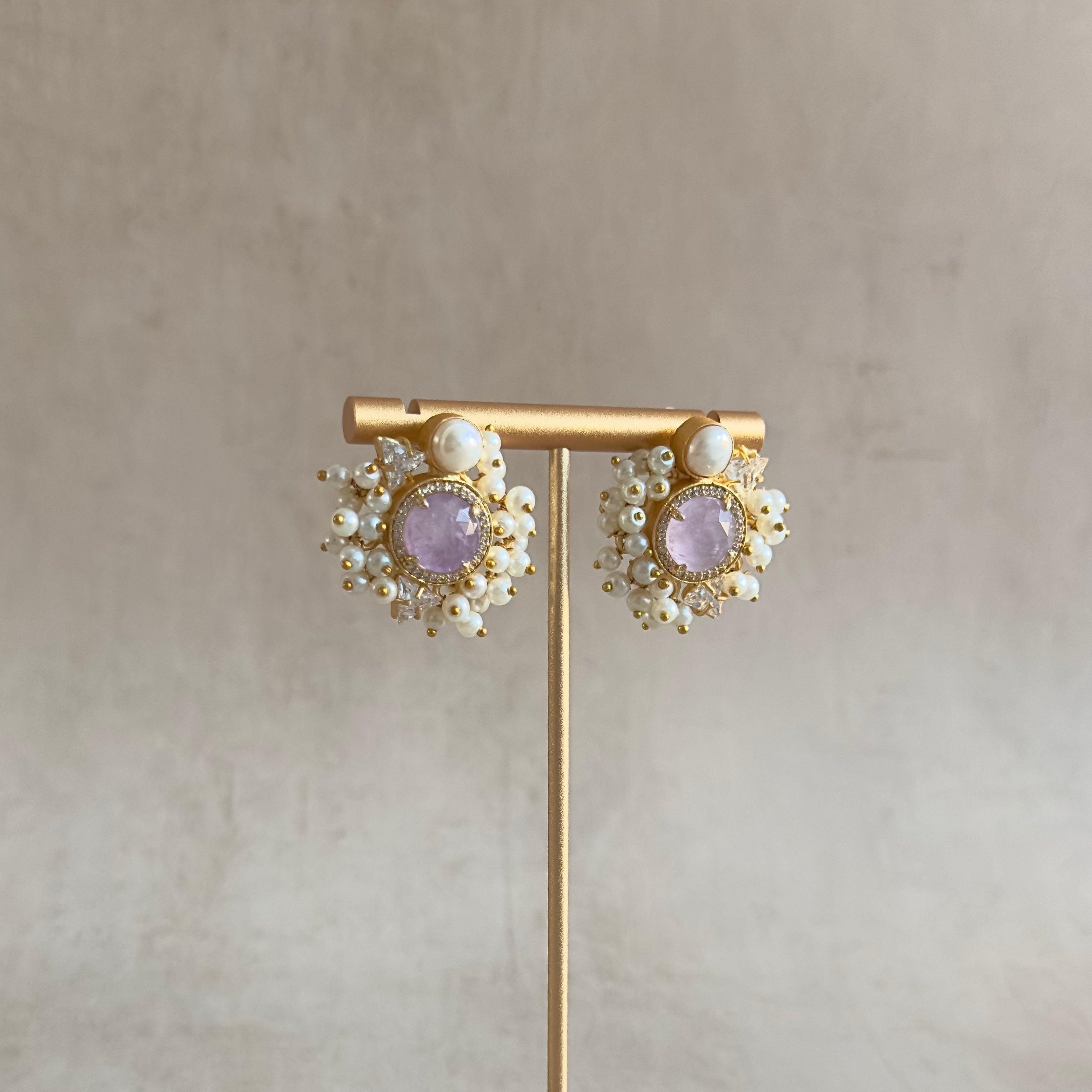 Enhance your everyday look with these Lilac Crystal Pearl Stud Earrings! The classic design paired with the pearl accent and sparkling CZ crystals will add a touch of elegance to any outfit. Make a statement and feel confident wearing these stunning studs.