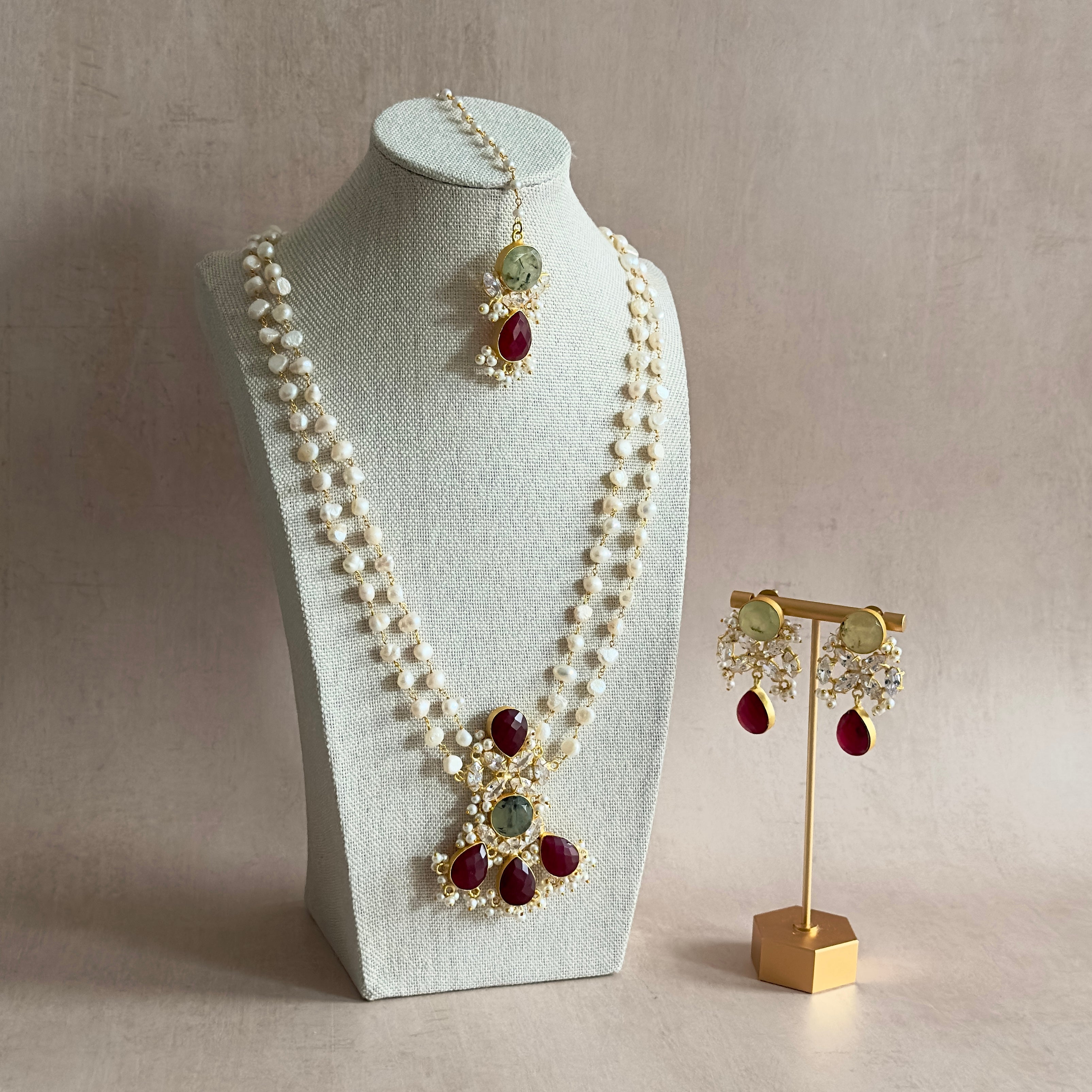 Get ready to turn heads with the Madiha Crystal Mala Set! This stunning 3-piece set features deep red and prehnite gemstones, adding elegance and charm to any outfit. The adjustable tie ensures a perfect fit, and it comes complete with earrings and tikka for a glamorous look. Perfect for a touch of sparkle and shine!