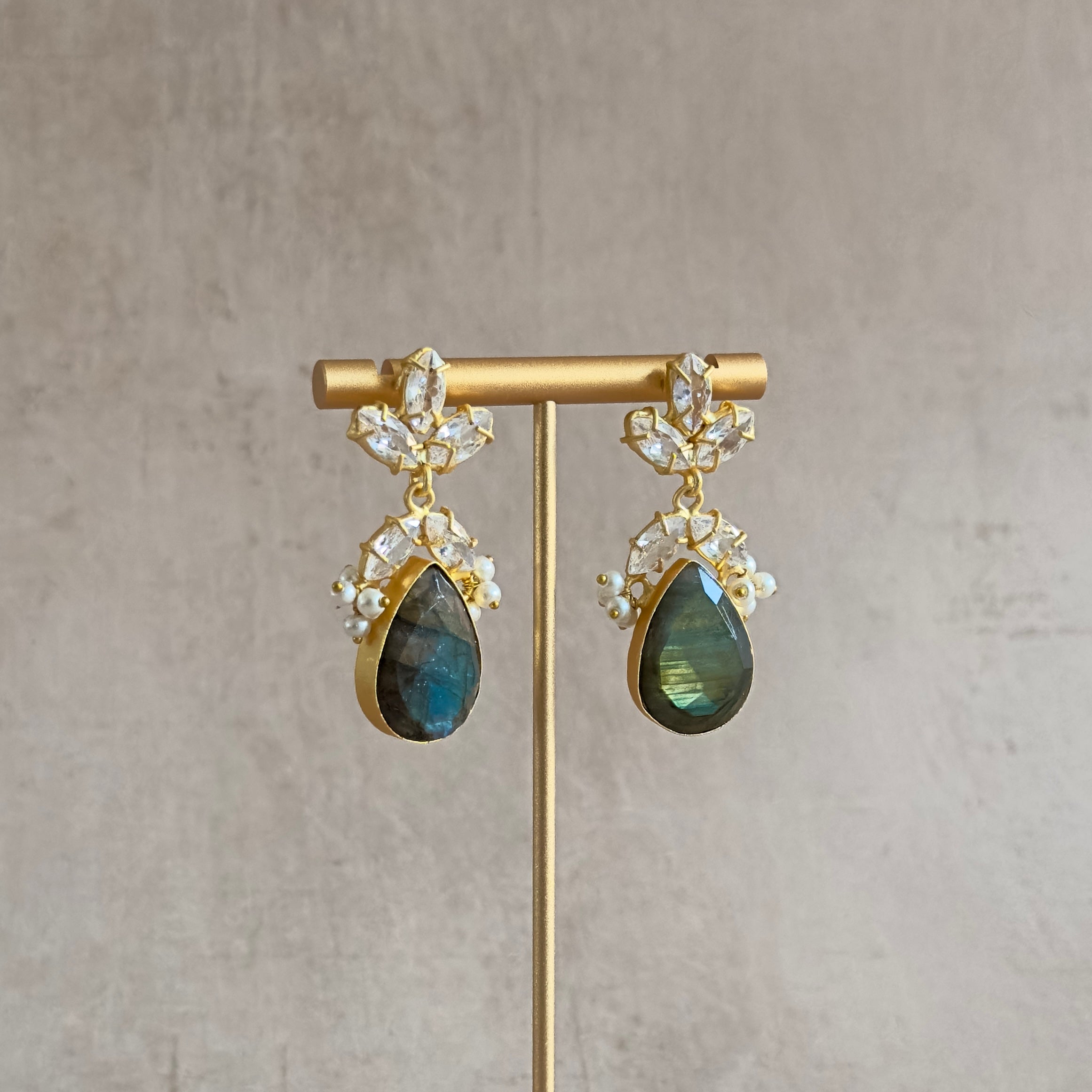Indulge in the luxurious elegance of Cairo Crystal Drop Earrings. Each pair features stunning labradorite gemstones and sparkling CZ crystals, adding a touch of sophistication to any outfit. Elevate your style and turn heads with these beautiful statement earrings.