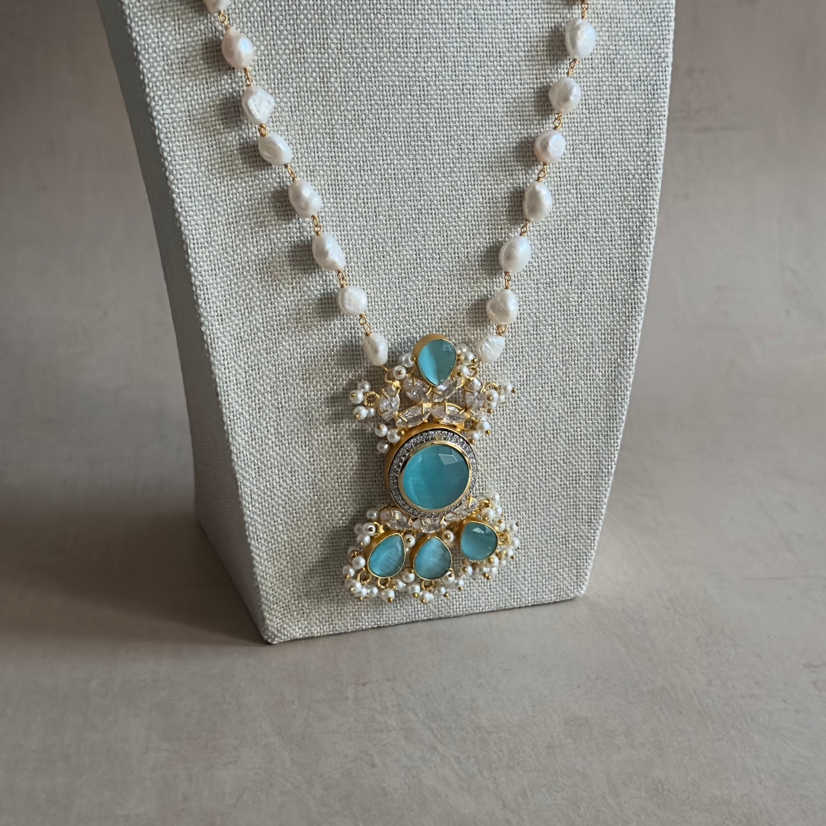 Elevate your style with our Amelia Blue Mala Set! This stunning long necklace set features aqua blue stones and sparkling cz crystals that will catch everyone's eye. Complete with matching earrings, this set is perfect for any occasion. Add a touch of elegance to your ensemble.
