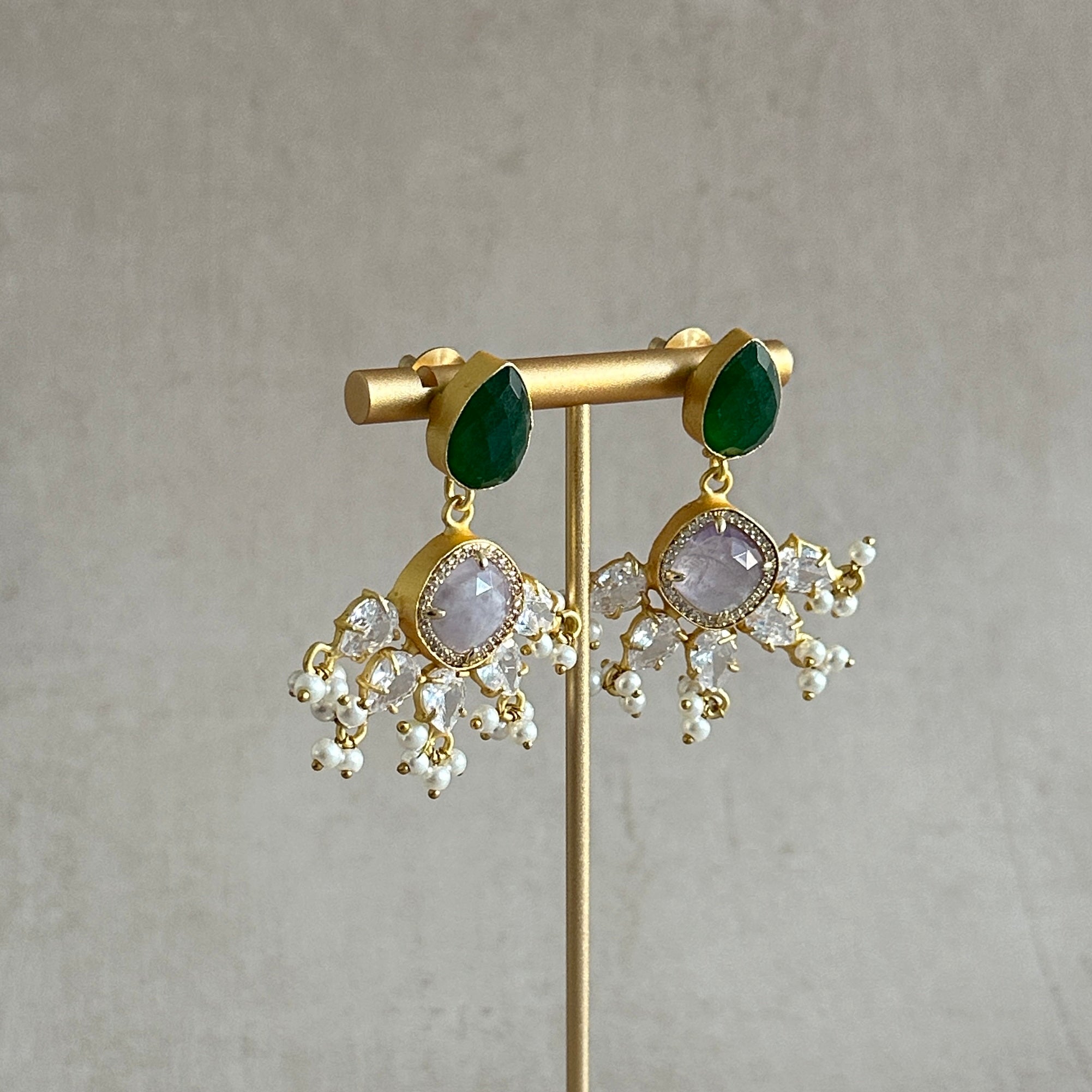 These Harper Green Drop Earrings feature a stunning mix of green and lilac hues, creating a striking and versatile accessory. Adorned with cz crystals, these earrings add an elegant sparkle to any outfit. Elevate your style with these must-have earrings!