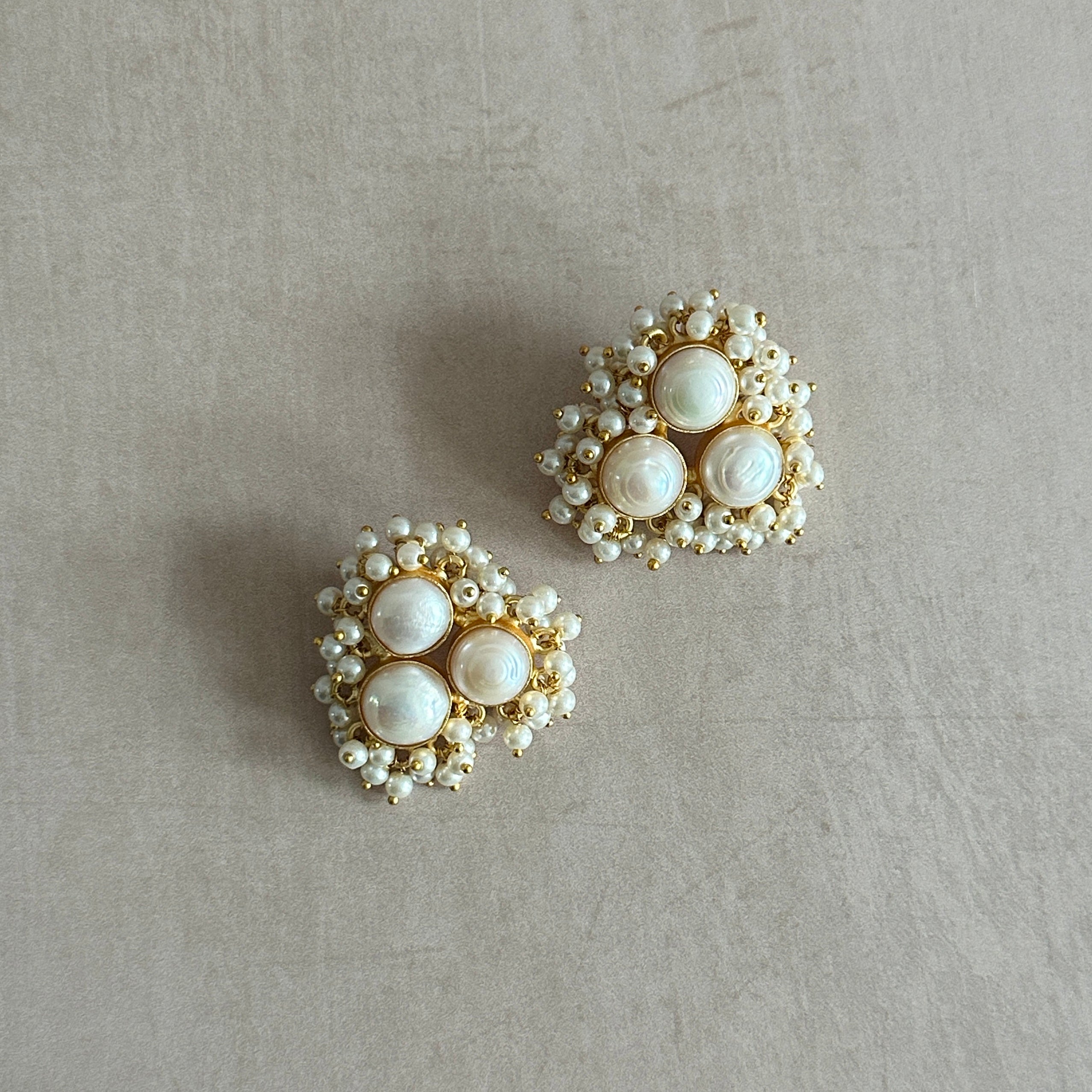 Elevate any outfit with the Fahema Pearl Stud Earrings. Made with natural freshwater pearls, the trio design features unique shapes and textures, adding a touch of elegance and sophistication. Perfect for any occasion, these earrings are a must-have for any jewelry lover.