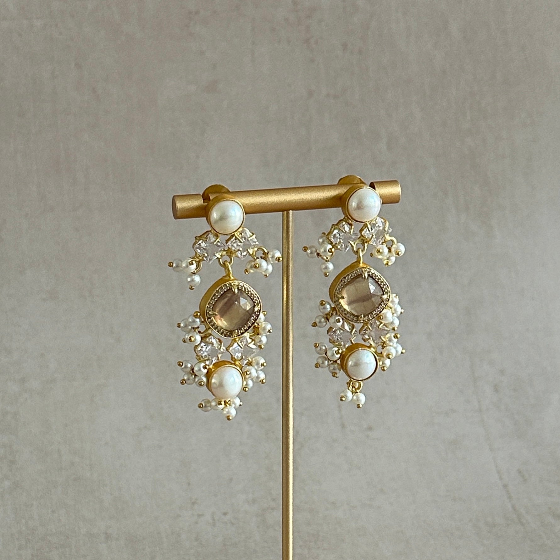 Behold the beauty of these exquisite Sana Honey Quartz Earrings. Crafted from shimmering honey quartz and adorned with pearl accents and sparkling cz crystals, these earrings are perfect for any special occasion. Add an air of refinement and sophistication to your style with these luxurious earrings.