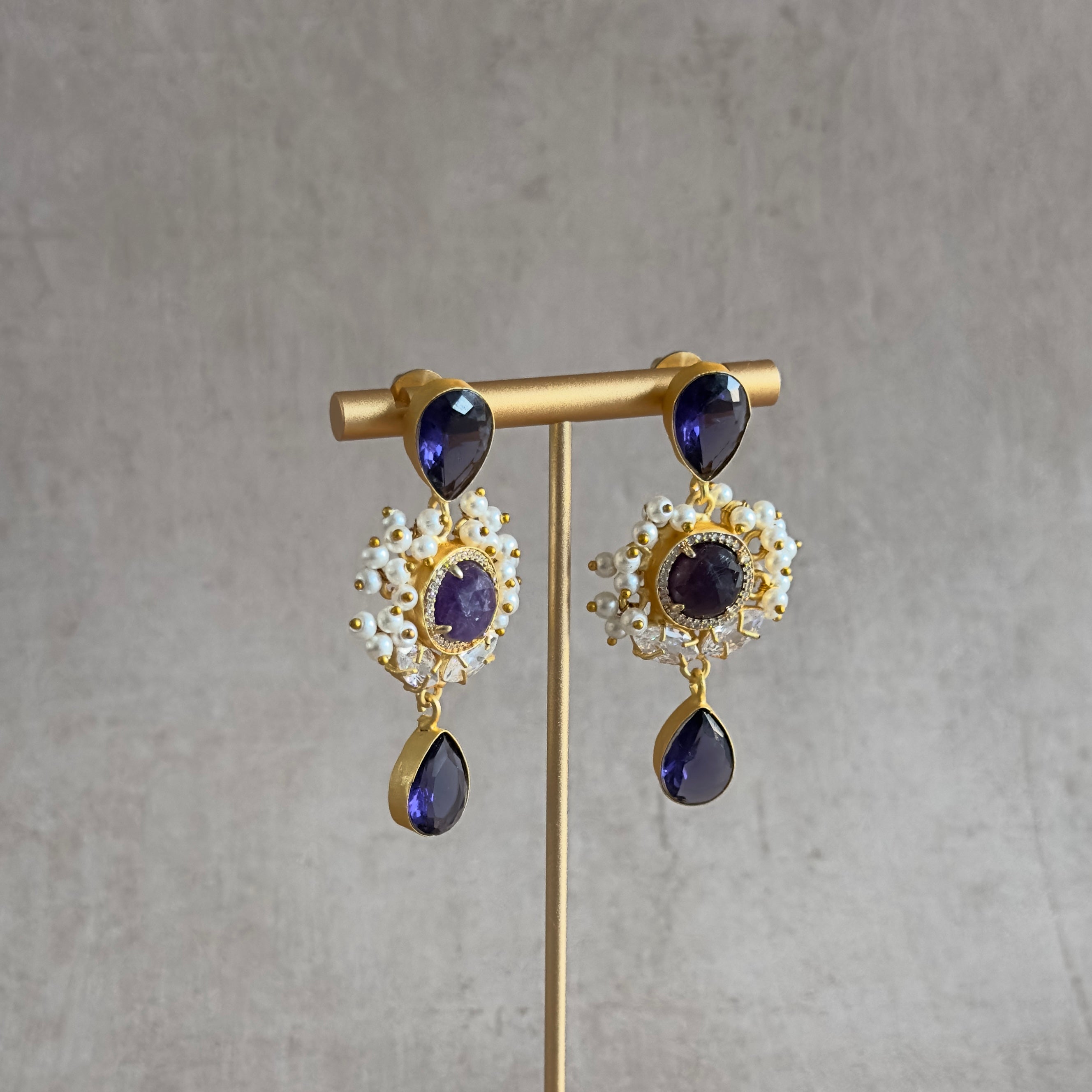 "Get ready to sparkle with these hand-cut gemstone Purple Drop Earrings! The cz crystals add a touch of shine to any outfit, making these earrings the perfect addition to your jewelry collection. Show off your unique style with these playful, yet elegant, earrings.&nbsp;