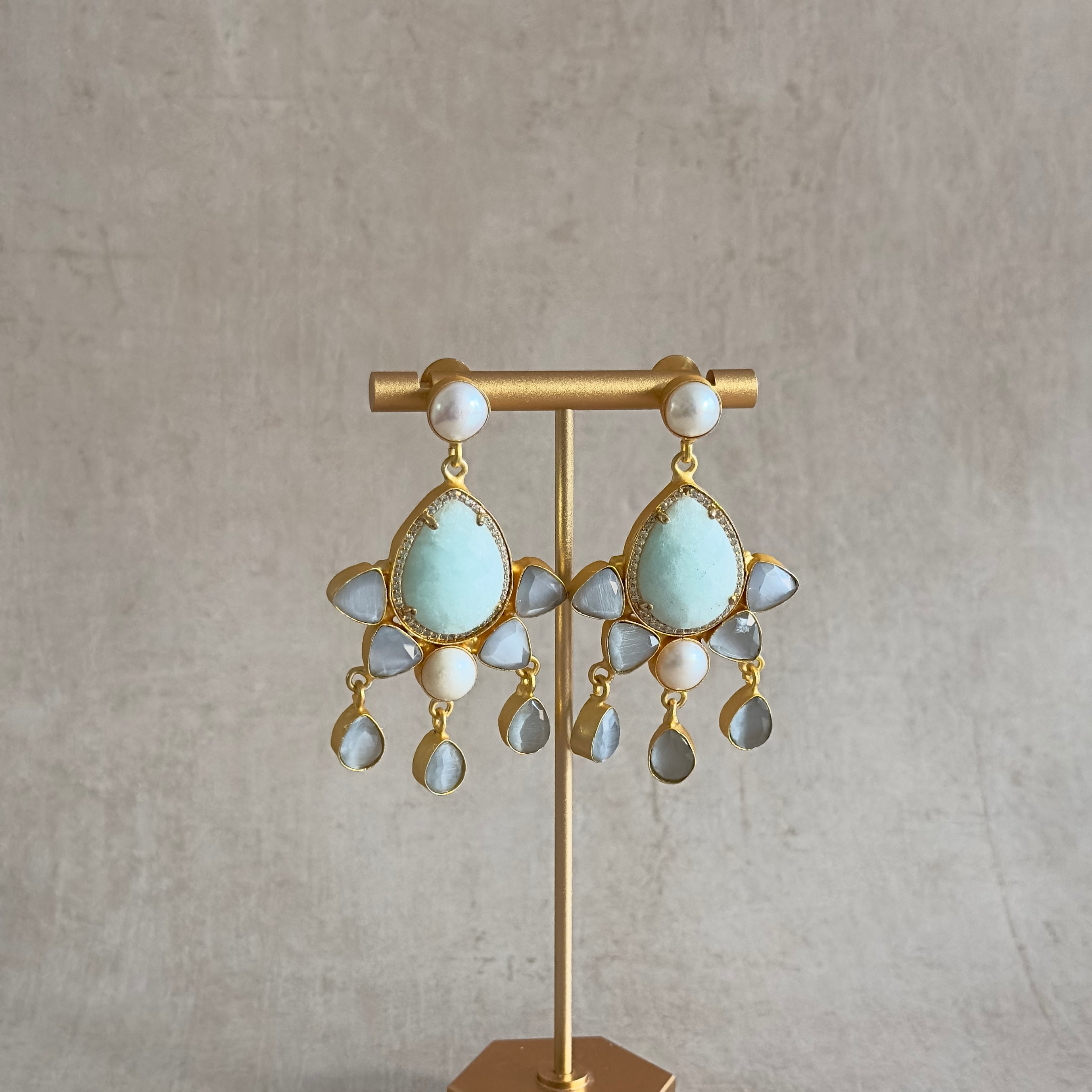 Exude elegance and charm with our Nara Grey Drop Earrings. Featuring stunning hues of jade and grey, these earrings are accented with lustrous pearls for a truly glamo