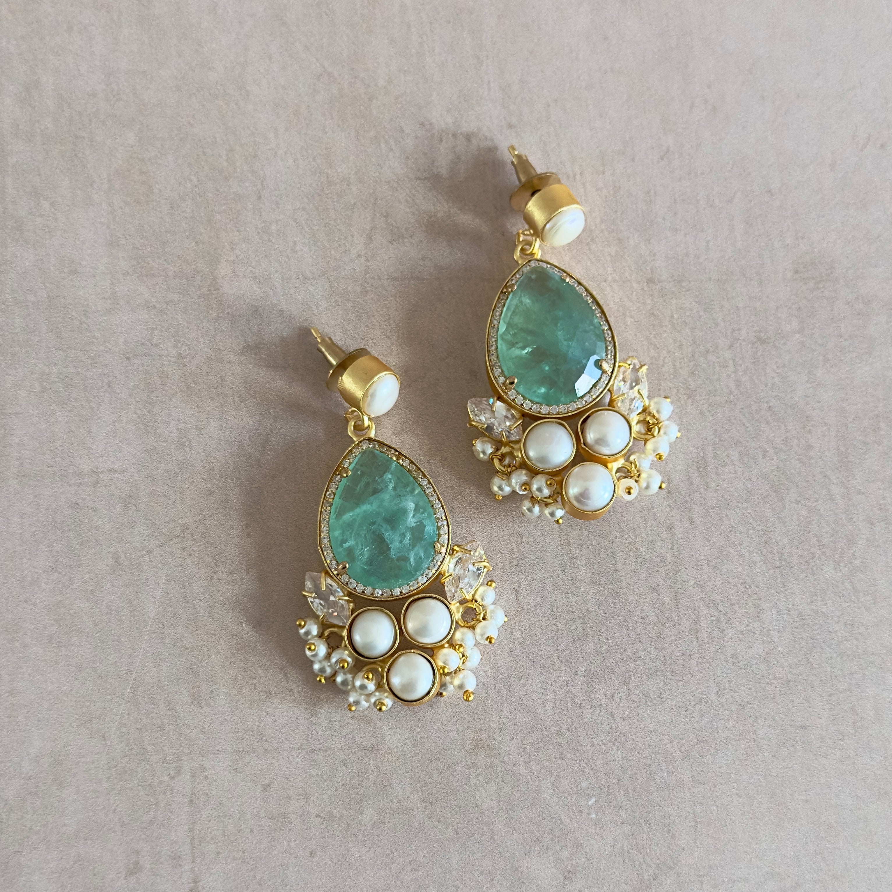 Indulge in the perfect blend of ocean-inspired beauty and elegance with our Malaia Mint Pearl Drop Earrings. Each piece is carefully crafted with aquamarine crystals and sparkling cubic zirconia, offering a touch of the sea's enchantment to your style. Elevate your look with these stunning and timeless earrings.