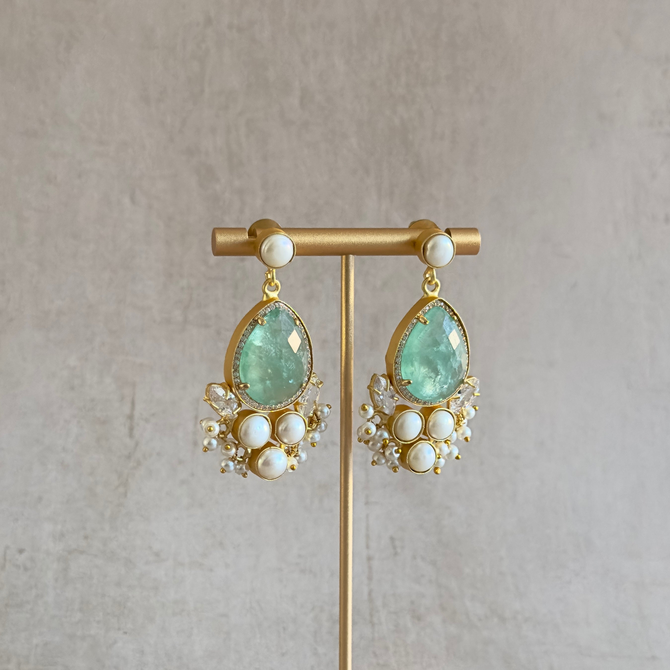 Indulge in the perfect blend of ocean-inspired beauty and elegance with our Malaia Mint Pearl Drop Earrings. Each piece is carefully crafted with aquamarine crystals and sparkling cubic zirconia, offering a touch of the sea's enchantment to your style. Elevate your look with these stunning and timeless earrings.