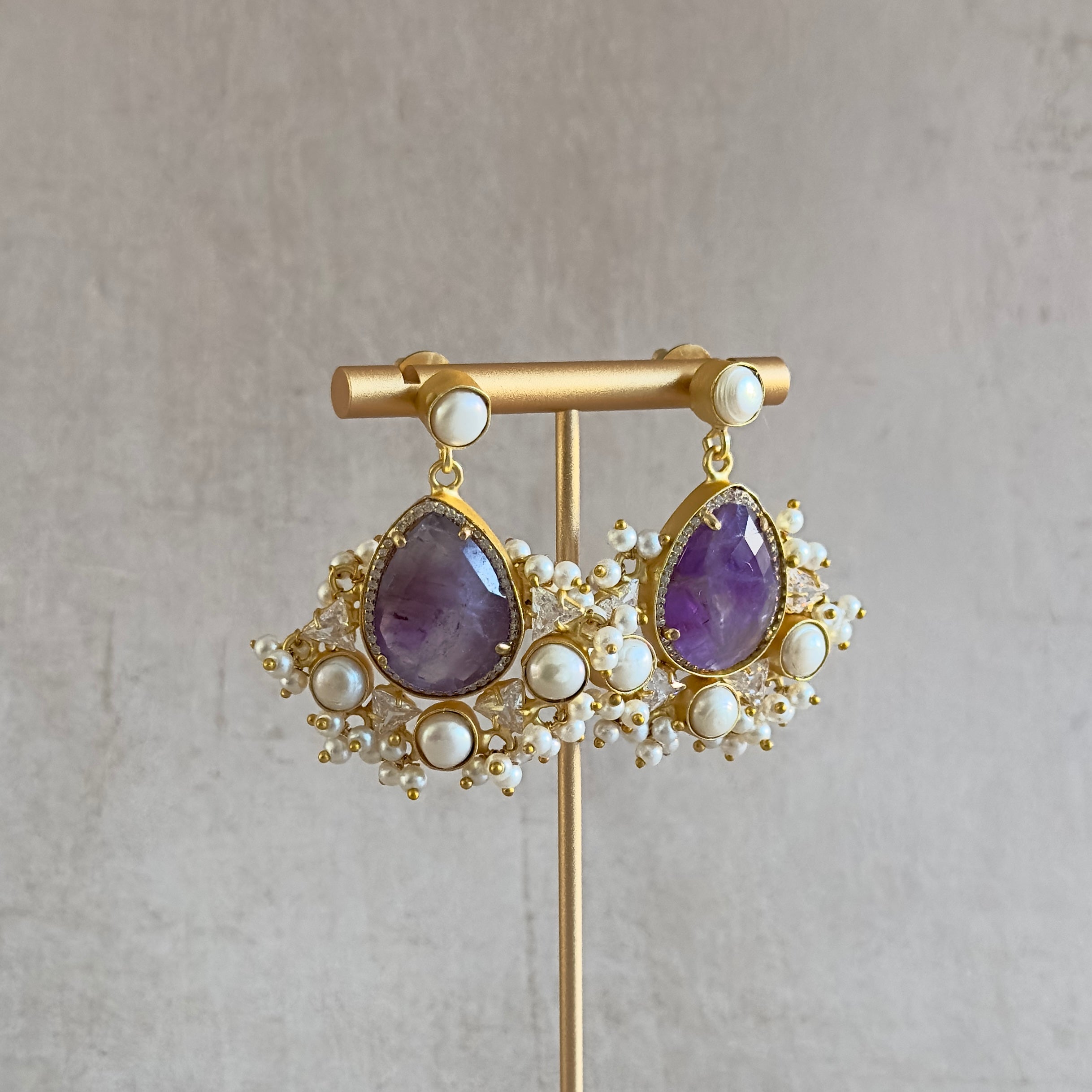 Introducing the Poppy Purple Drop Earrings - the perfect combination of elegant amethyst stone, delicate pearl accents, and shining cz crystals! Experience the beauty of nature with these stunning earrings that will add a touch of sophistication and grace to any outfit.