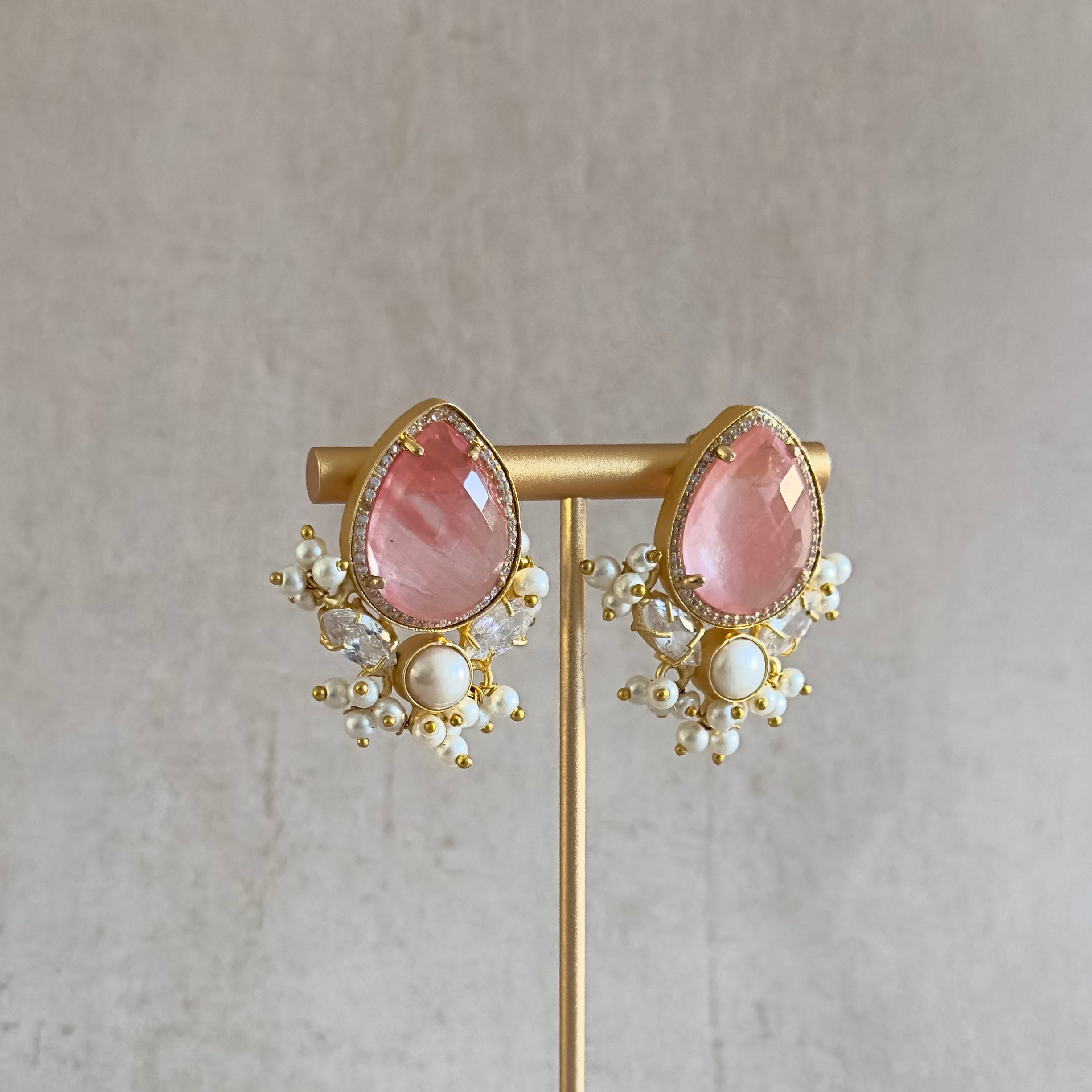 Add a touch of elegance with our new Bria Earrings featuring a crimson quartz center stone, pearl accents, and sparkling cz crystals. Elevate any outfit with a pop of color and shine. A must-have for the fashion-forward.