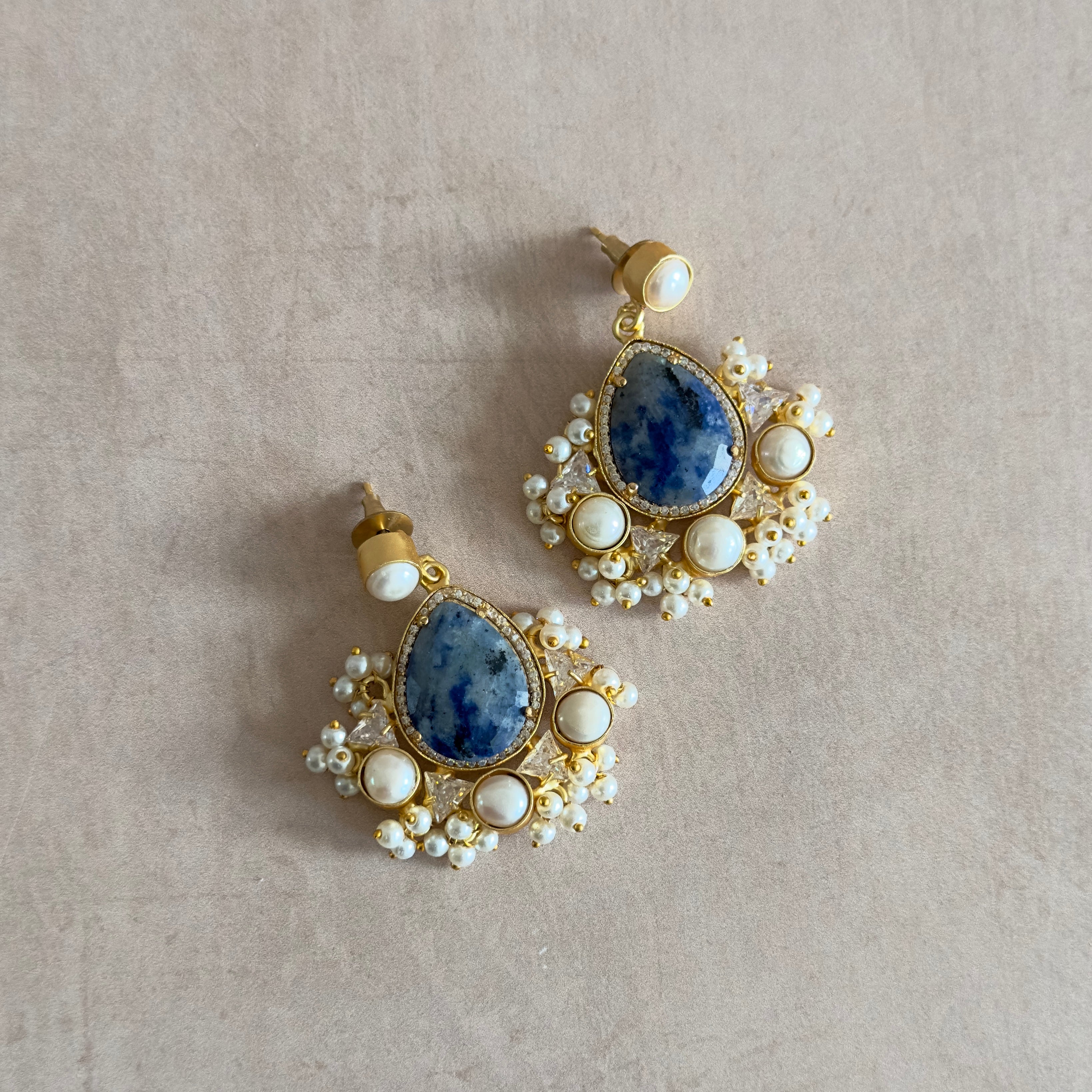 Elevate your style with our Poppy Blue Pearl Drop Earrings! Crafted with natural blue marble gemstones, pearl accents, and sparkling crystal details, these earrings add a touch of elegance to any outfit. Enhance your look with the beauty and uniqueness of these stunning earrings.
