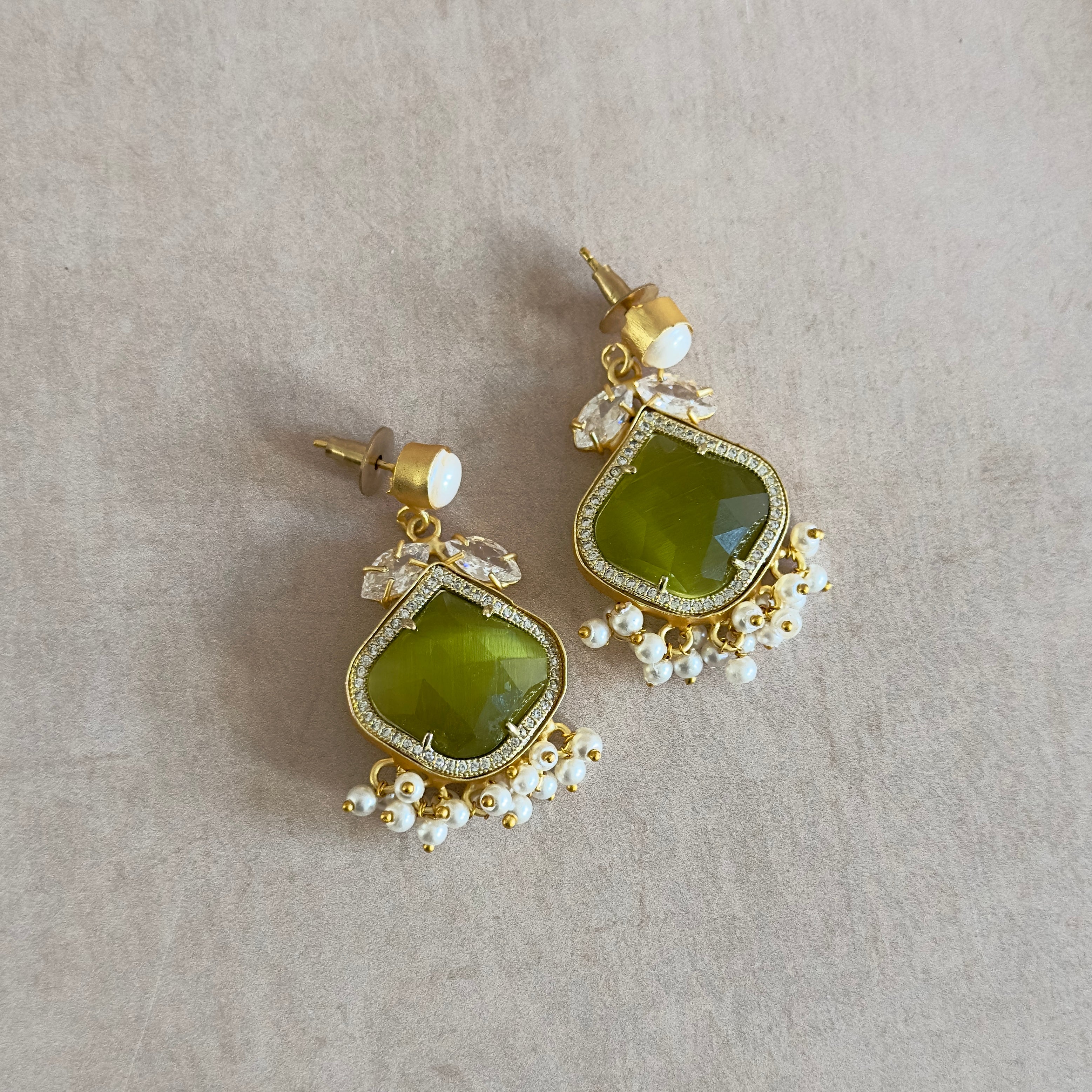 Elevate your style with our Gaia Olive Pearl Drop Earrings! The stunning vibrant olive stone paired with a delicate pearl accent and sparkling crystal details will add a touch of elegance to any outfit. Stand out and make a statement with these eye-catching earrings.