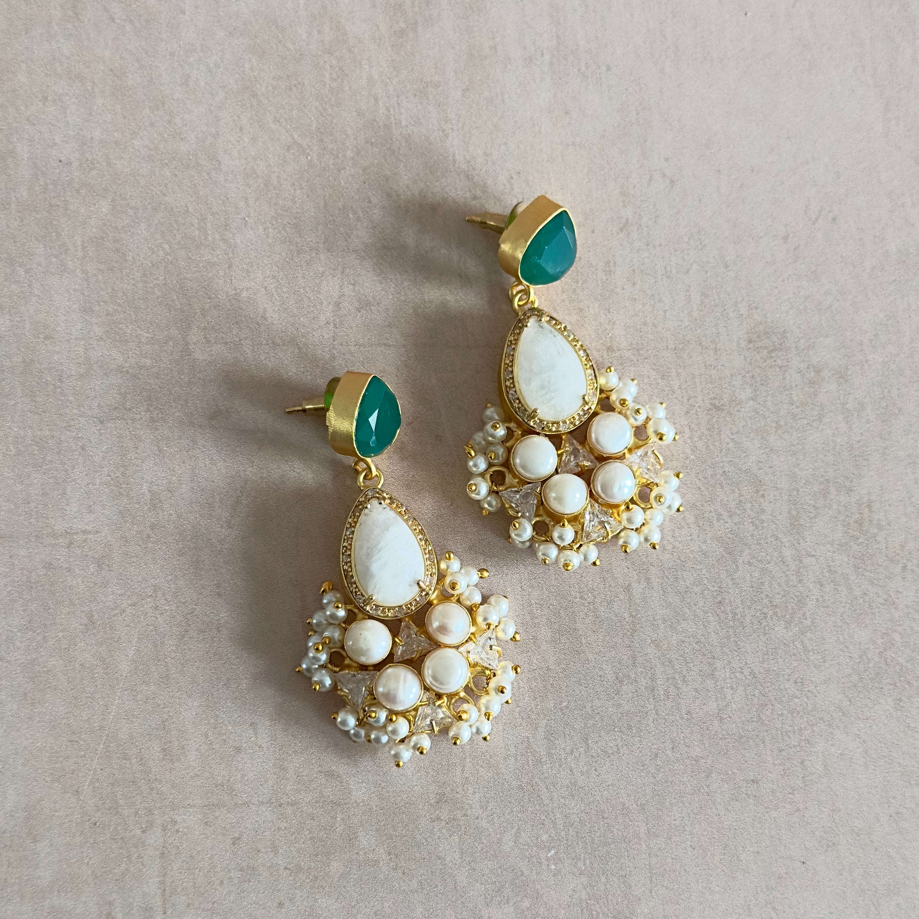 Elevate your look with the Romee Green Drop Earrings! The stunning hues of green and pearl complemented by white quartz crystals exude a sense of elegance and luxury. Add a touch of sophistication to any outfit and make a statement wherever you go. Get ready to turn heads and feel confident in these beautiful earrings!