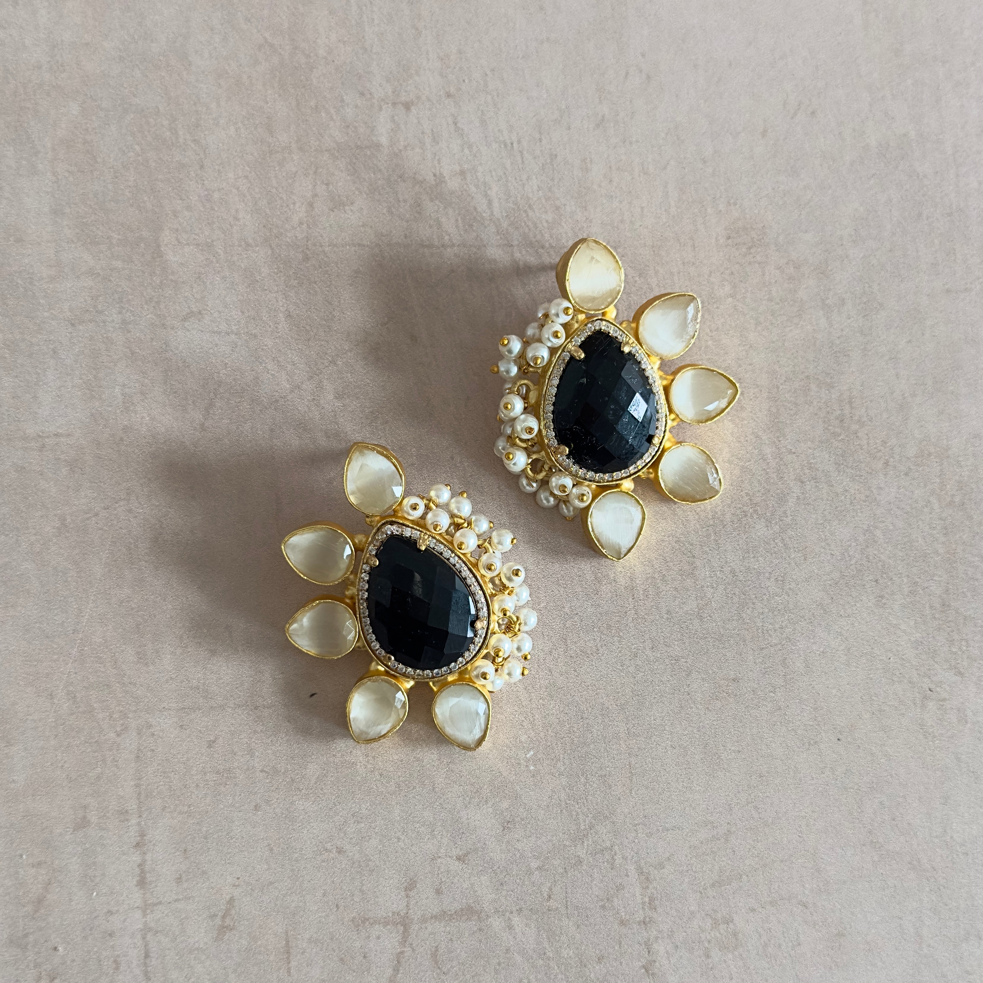 Elevate your style with our Amara Black Stud Earrings! Made with black onyx and grey stones, these statement studs are perfect for adding a touch of sophistication to any outfit. Add these to your collection and make a bold statement with every wear!