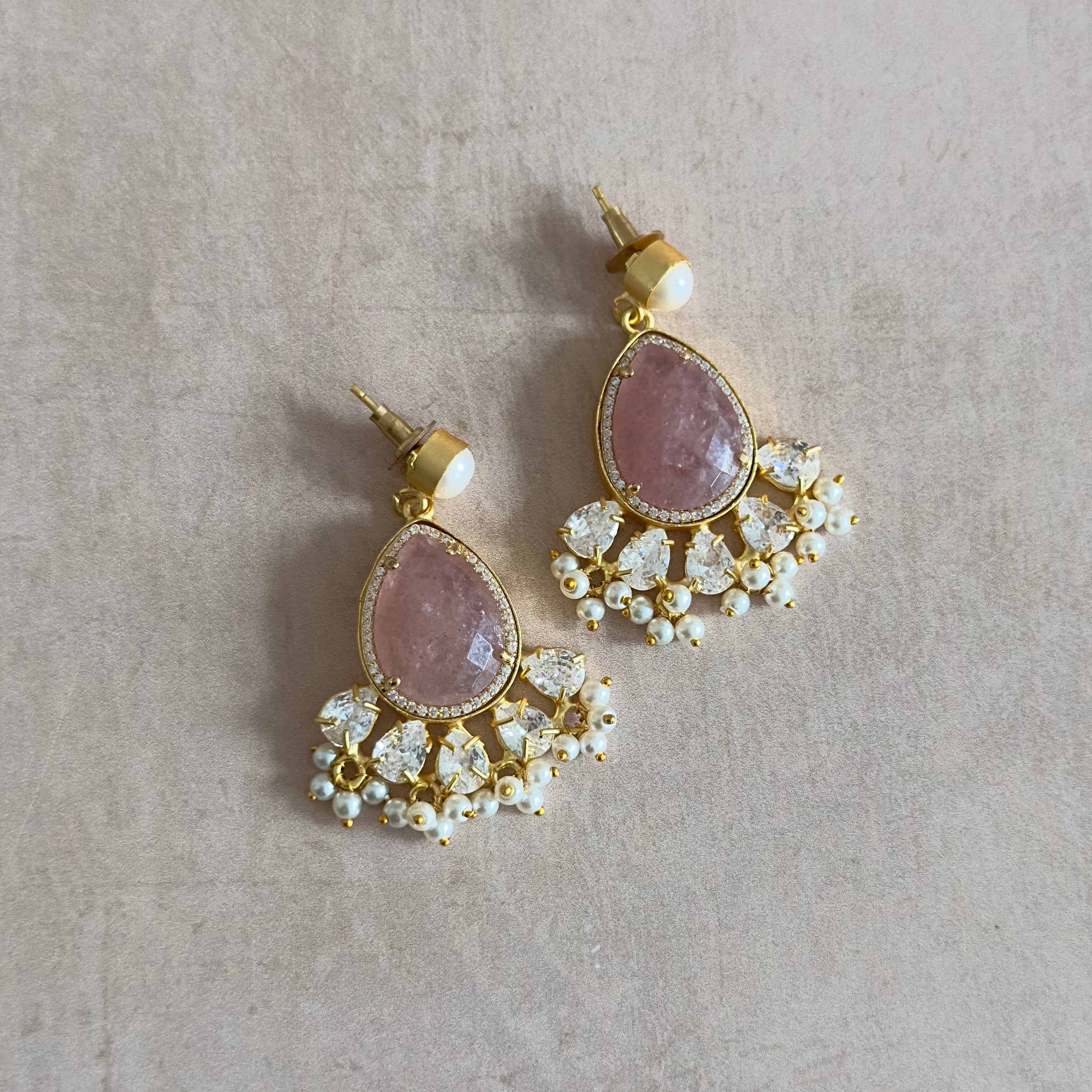 Bring out your inner grace with our Ciana Pink Crystal Pearl Drop Earrings. These rustic pink crystal stones, accented with cubic zirconia and a shimmering pearl, will add a touch of elegance to any outfit. Elevate your style and make a statement with these stunning earrings!