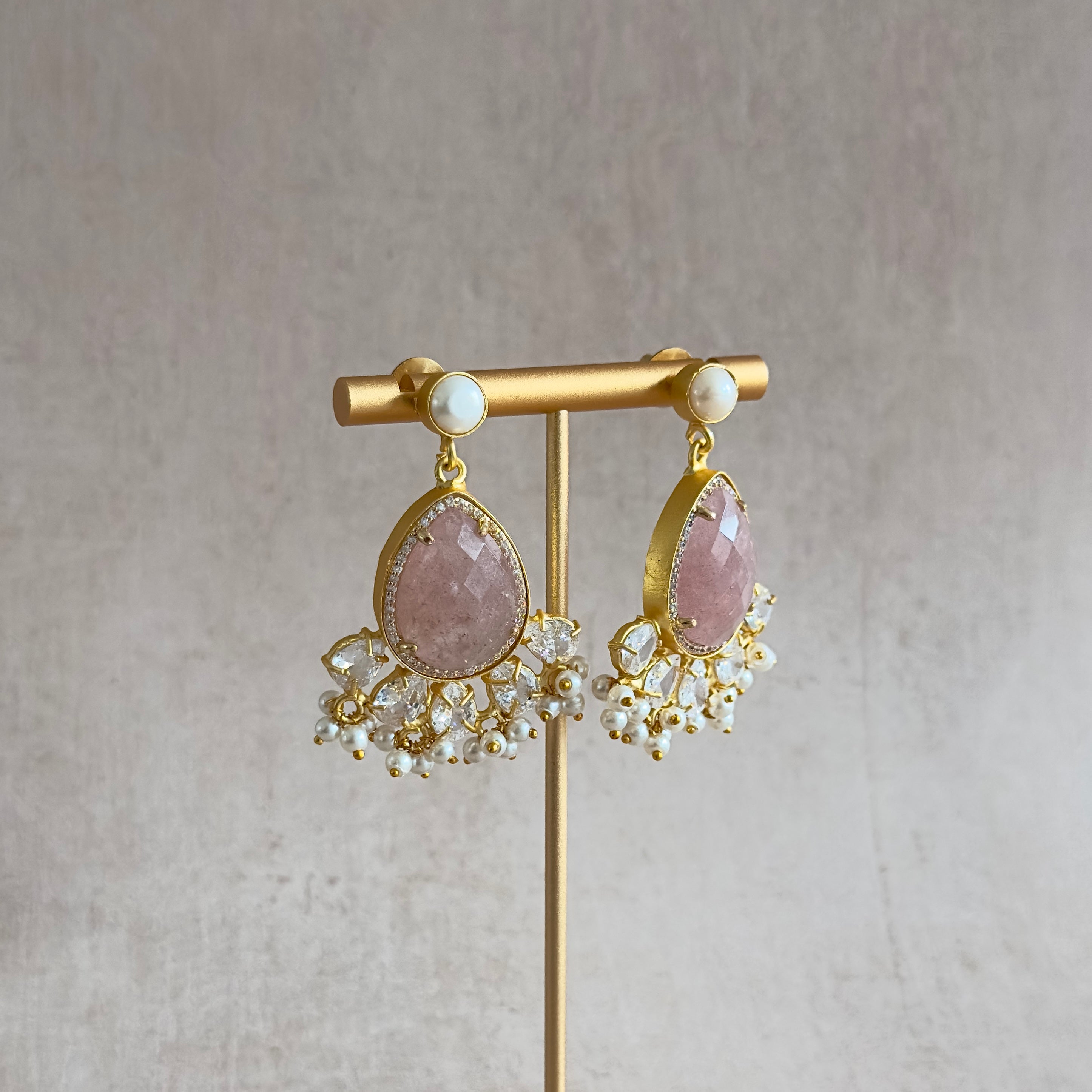 Bring out your inner grace with our Ciana Pink Crystal Pearl Drop Earrings. These rustic pink crystal stones, accented with cubic zirconia and a shimmering pearl, will add a touch of elegance to any outfit. Elevate your style and make a statement with these stunning earrings!