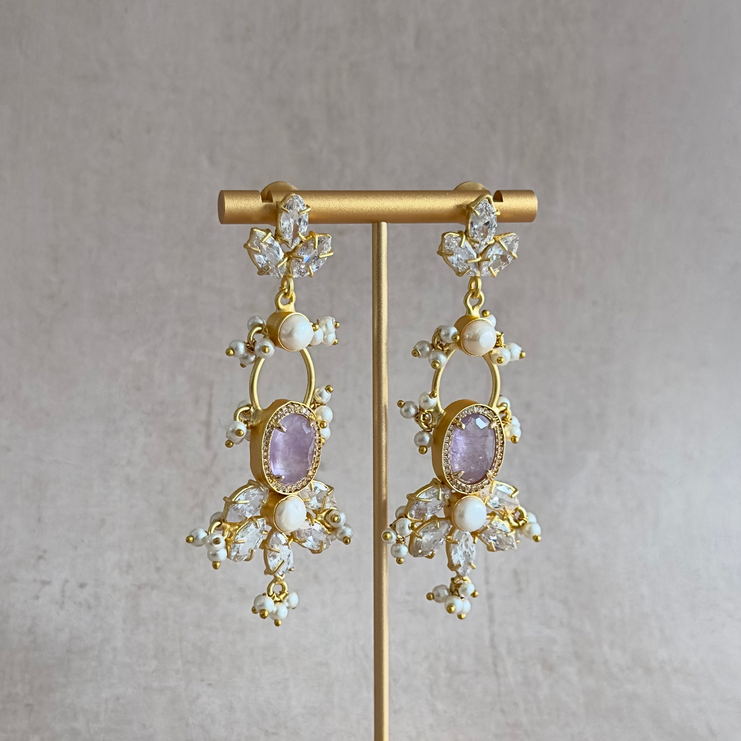 Indulge in pure elegance with our Sloane Lilac Crystal Drop Earrings. These stunning earrings are adorned with delicate lilac crystals, sparkling CZ crystals, and lustrous freshwater pearls. Elevate any outfit and turn heads with these statement earrings.
