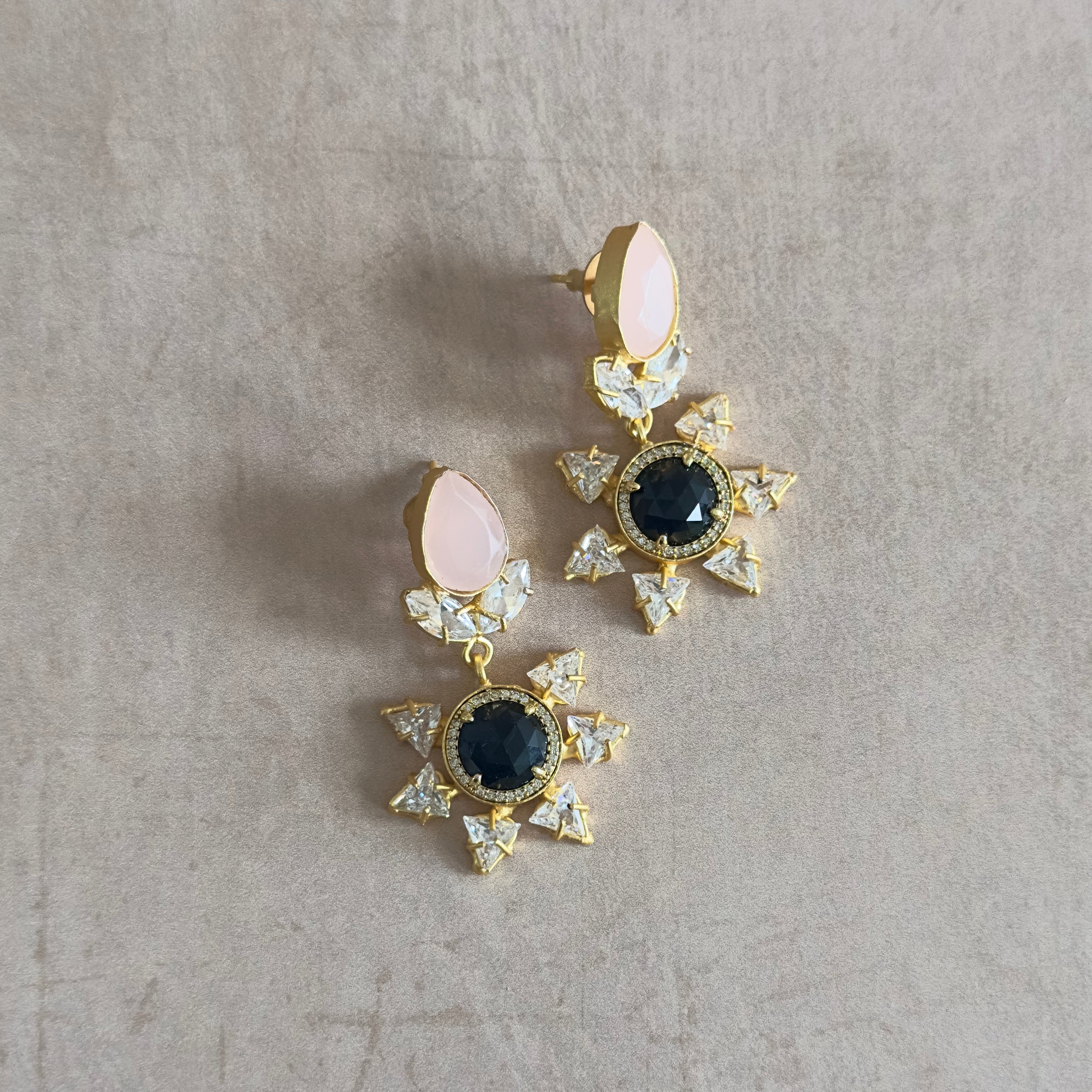 These Nelly Pink Drop Crystal Earrings are the perfect blend of sophistication and eye-catching style. The black onyx, pink stones, and CZ crystals come together to create a stunning combination that will elevate any outfit. Show off your unique sense of fashion with these must-have earrings.