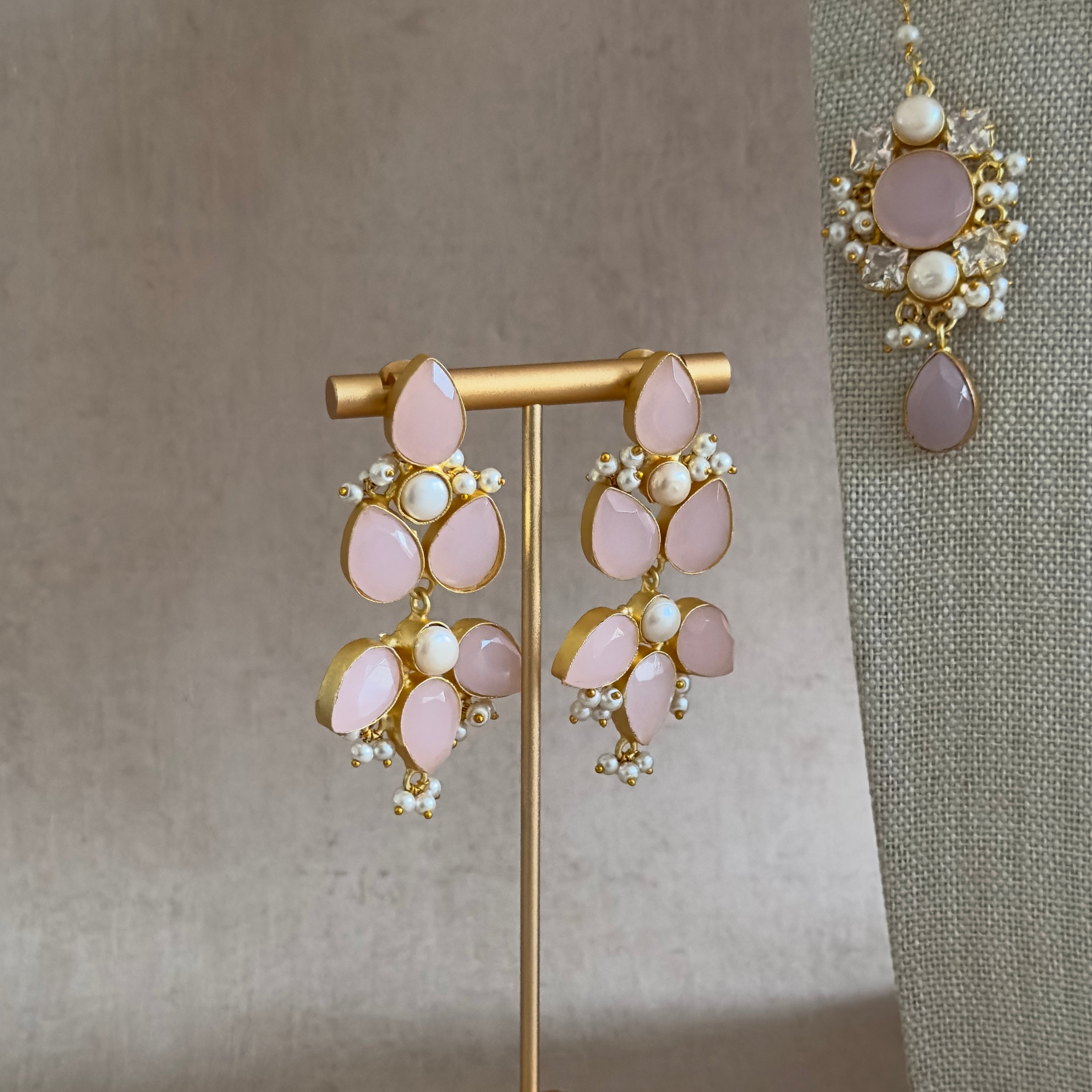Indulge in the rich beauty of our Bali Pink Necklace Set. The stunning pink color, paired with delicate pearl accents and dazzling cz crystals, will add a touch of elegance to any outfit. The adjustable tie allows for a perfect fit and the set includes matching earrings and tikka for a complete look. Elevate your style with this must-have accessory