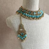 Elevate your accessories game with our Cassie Blue Choker Set. Featuring an antique gold finish and mesmerizing blue cateye stones, this set exudes sophistication. The adjustable fabric tie ensures a perfect fit, while the matching earrings and tikka complete the look. Make a luxurious statement with this must-have set.