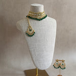 This Rani Green Kundan Choker Set is nothing short of exquisite. Featuring a delicate kundan setting, lush green beads, and captivating chaandbali earrings, this set is a must-have for those who appreciate the splendor of luxurious jewelry. The matching tikka completes the look, elevating it to a higher level of opulence.