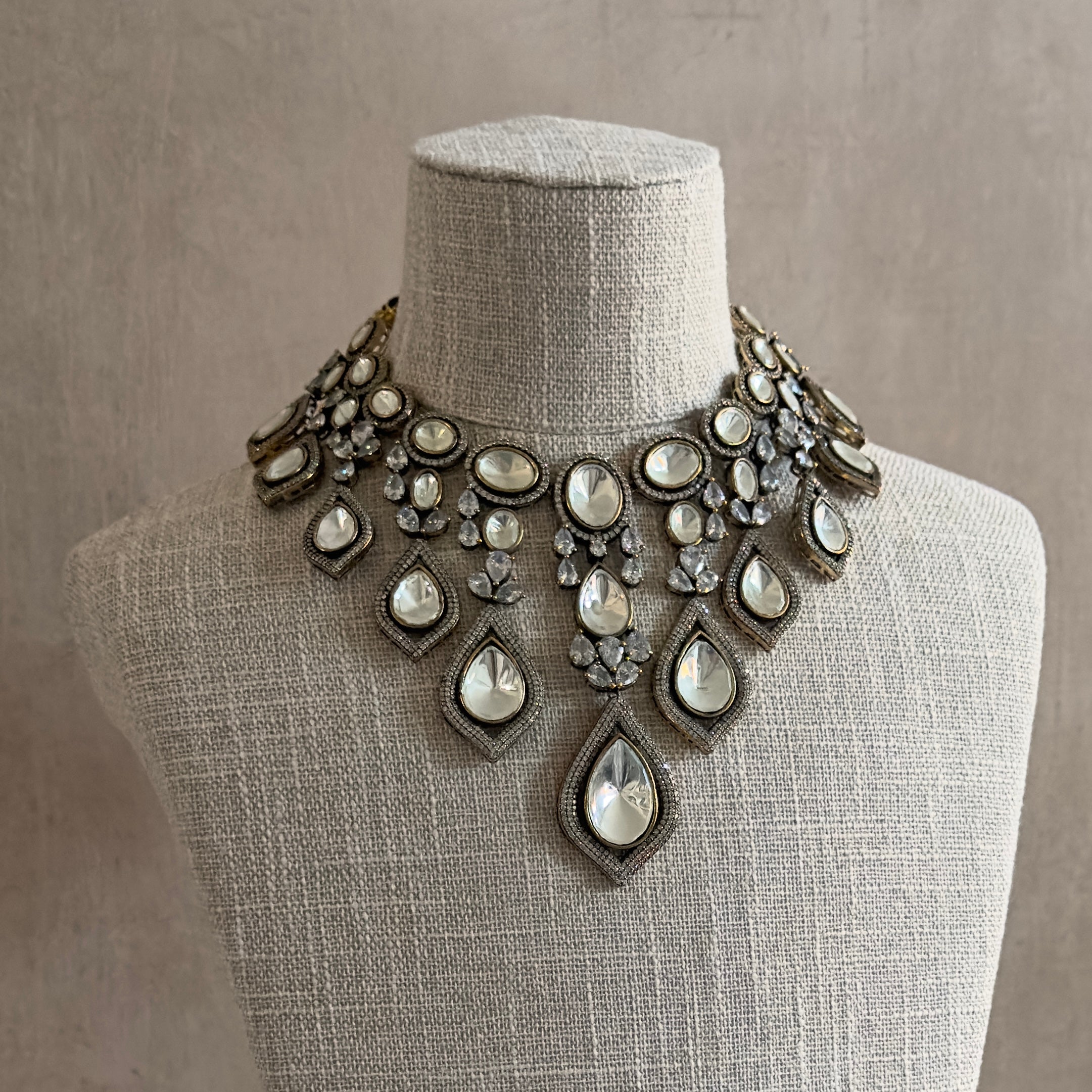 Channel the elegance and luxury of a peacock with our Polki Choker Set. Adorned with statement Polki and cz crystals, featuring an adjustable tie, this set exudes sophistication and style. Complete the look with the matching earrings for a truly stunning and exclusive ensemble.